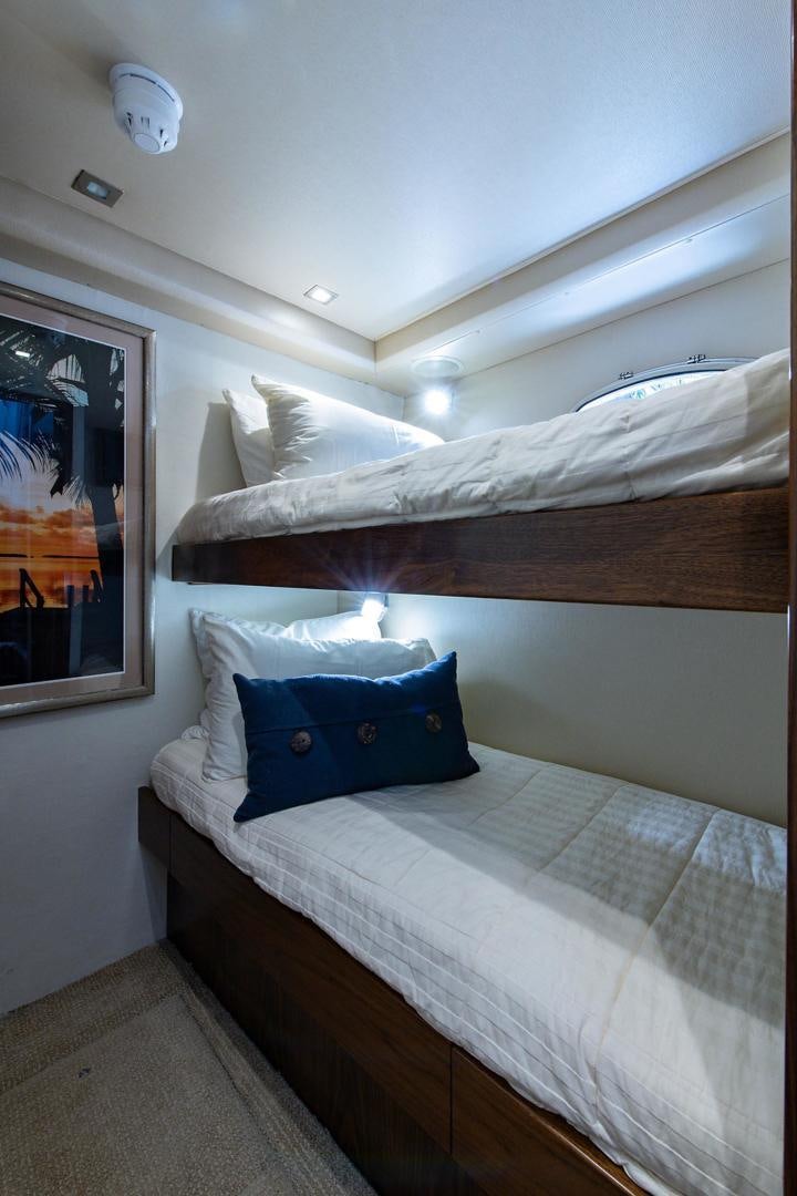 a bed with a blue pillow aboard OBSESSION Yacht for Sale