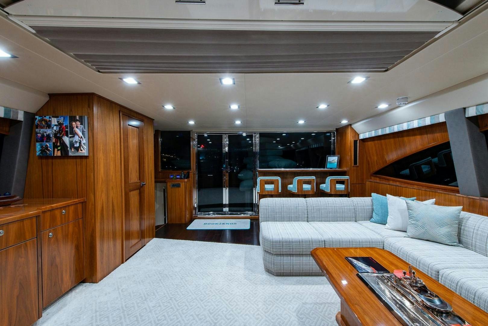 a living room with a couch and a wood cabinet aboard OBSESSION Yacht for Sale