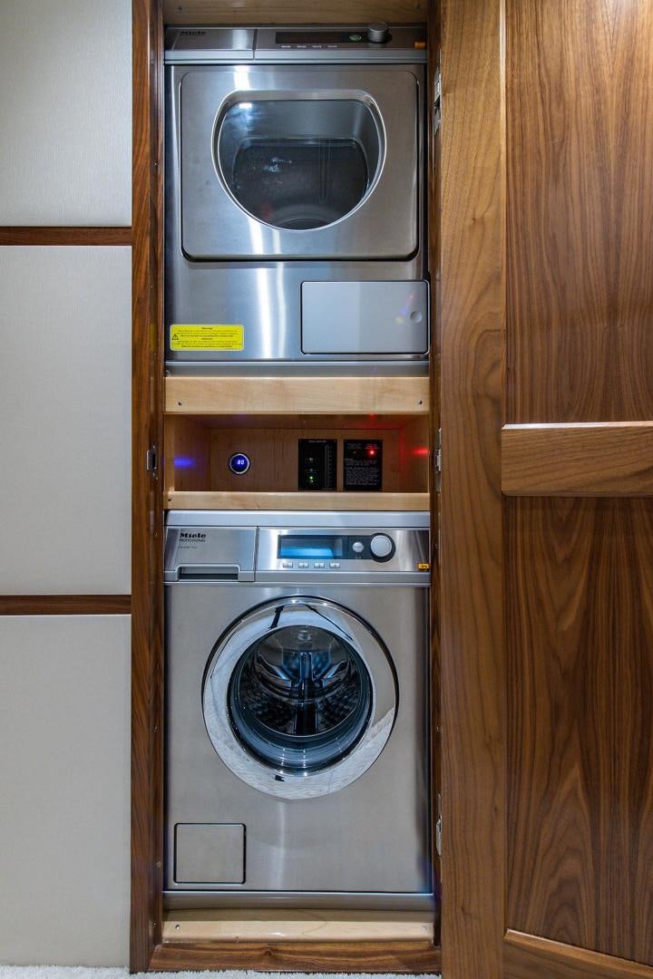 a washer and dryer in a closet aboard OBSESSION Yacht for Sale