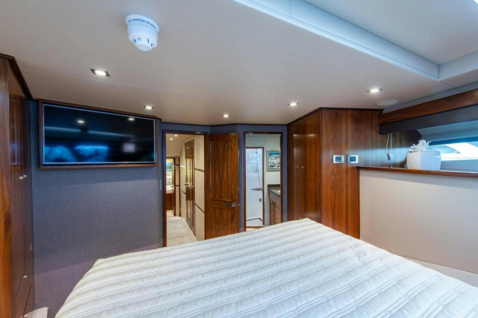 a bedroom with a bed and a television aboard OBSESSION Yacht for Sale