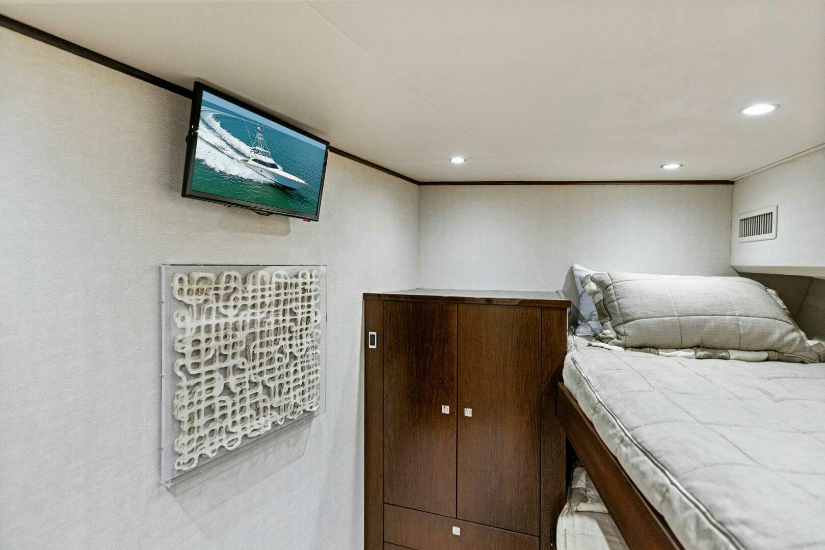 a bedroom with a bed and a tv on the wall aboard THE PROVIDER Yacht for Sale
