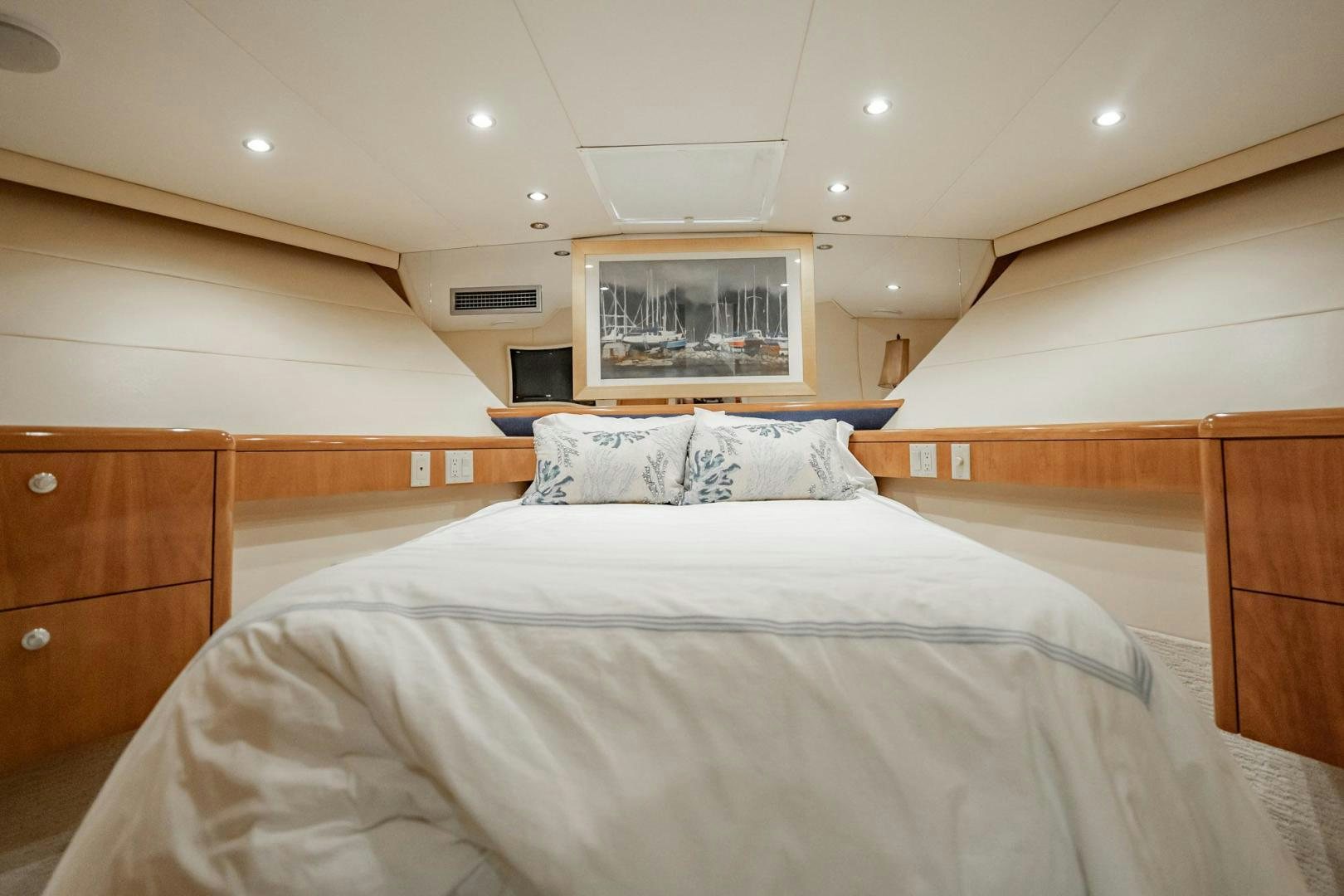 a bedroom with a bed and a wood dresser aboard CRISTINA Yacht for Sale