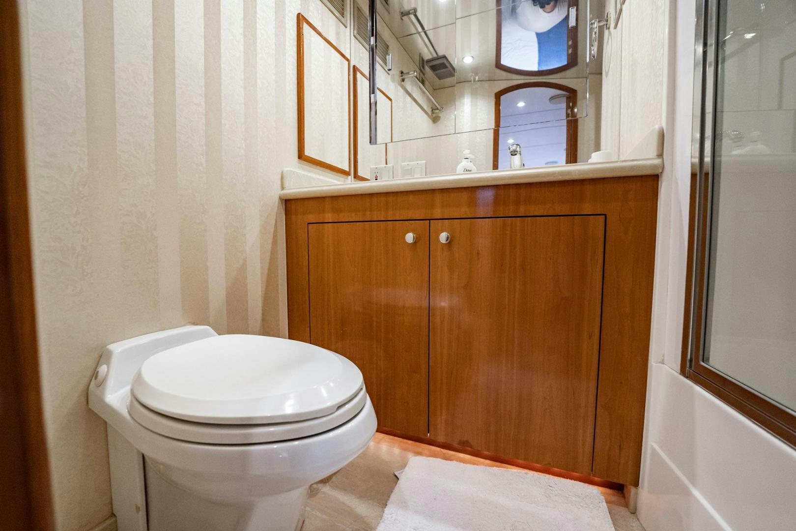 a bathroom with a toilet and a mirror aboard CRISTINA Yacht for Sale