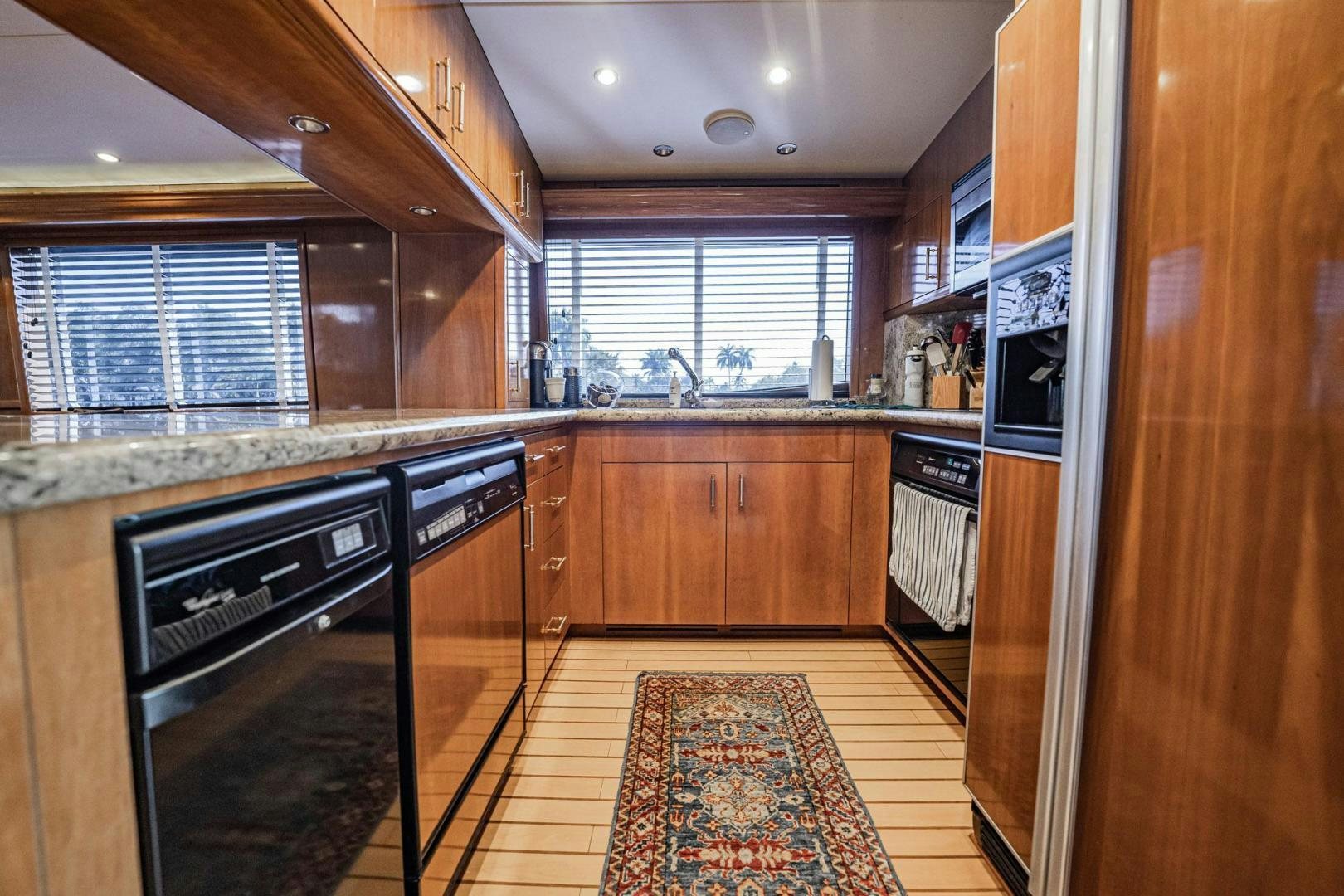 a kitchen with wooden cabinets aboard CRISTINA Yacht for Sale