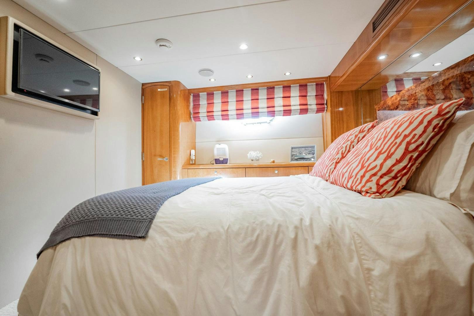 a bed with a television on the wall aboard CRISTINA Yacht for Sale