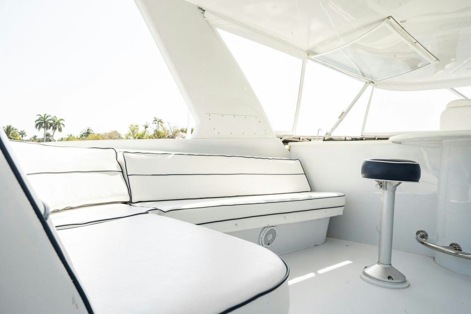 a white bed with a black seat aboard CRISTINA Yacht for Sale