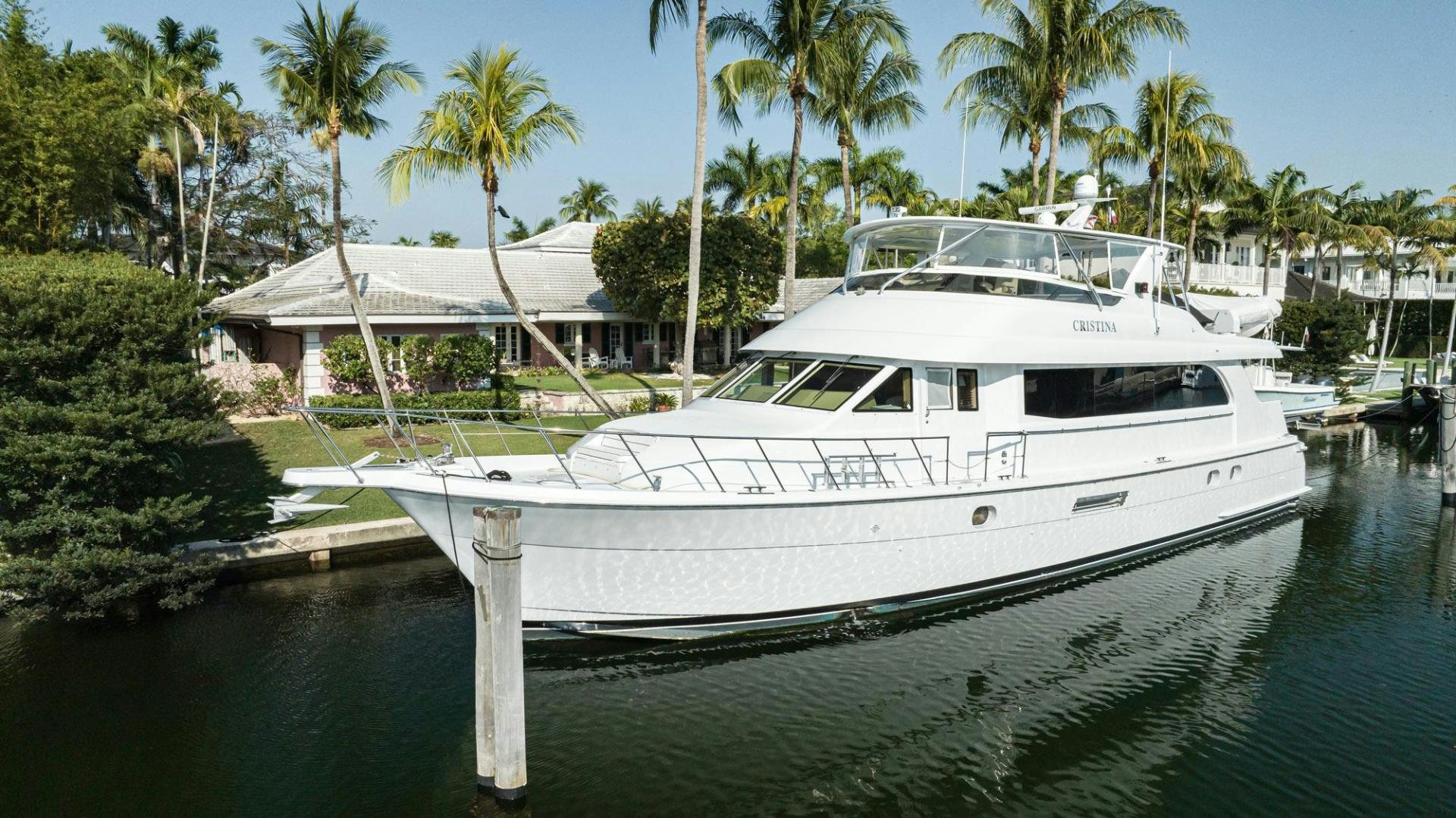 a white yacht in a tropical bay aboard CRISTINA Yacht for Sale