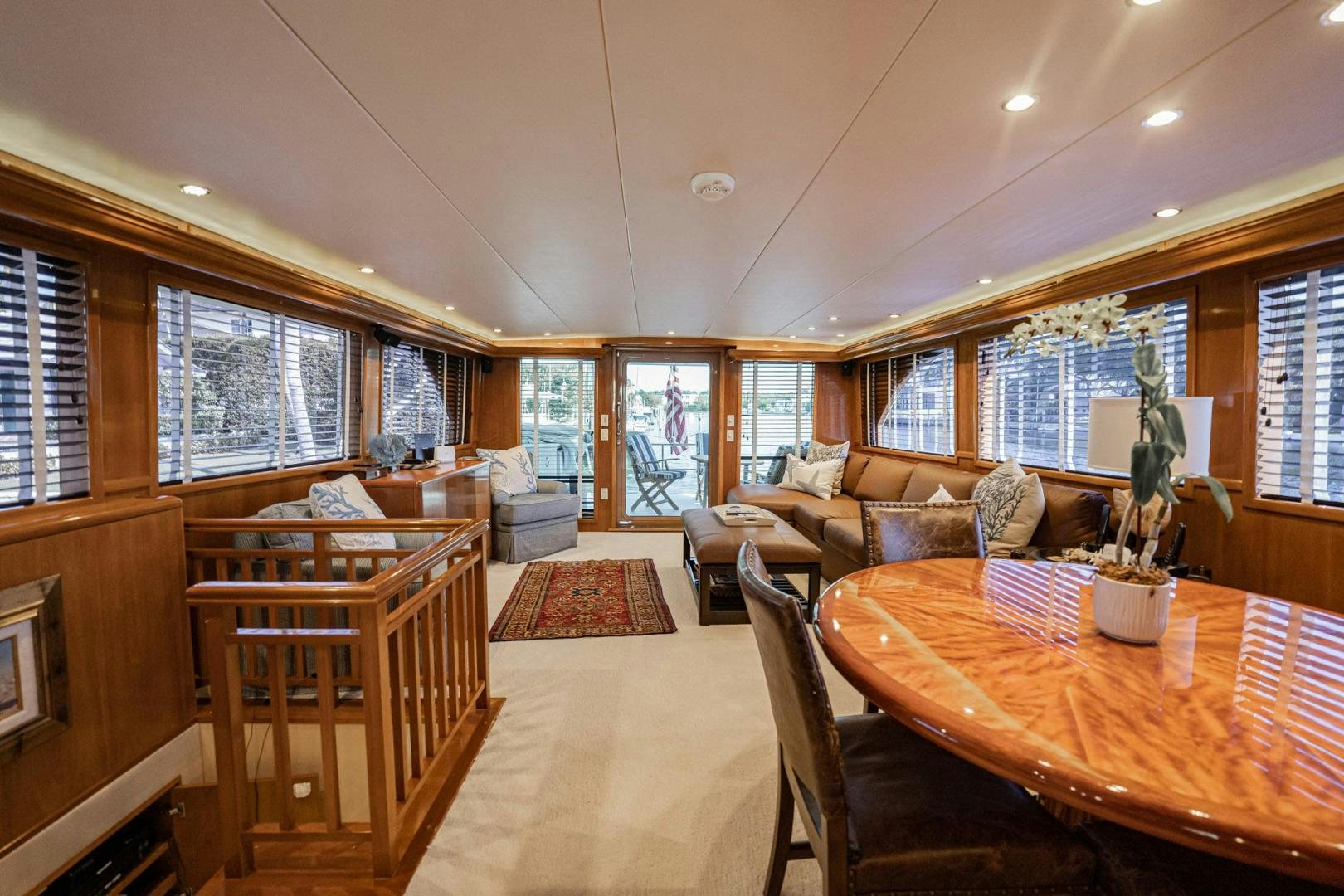 a large living room with a dining table and couches aboard CRISTINA Yacht for Sale