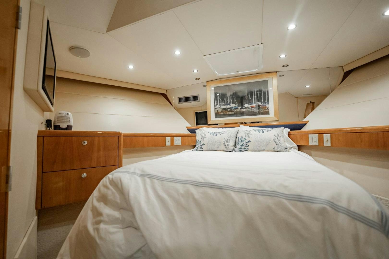 a bedroom with a bed and a dresser aboard CRISTINA Yacht for Sale