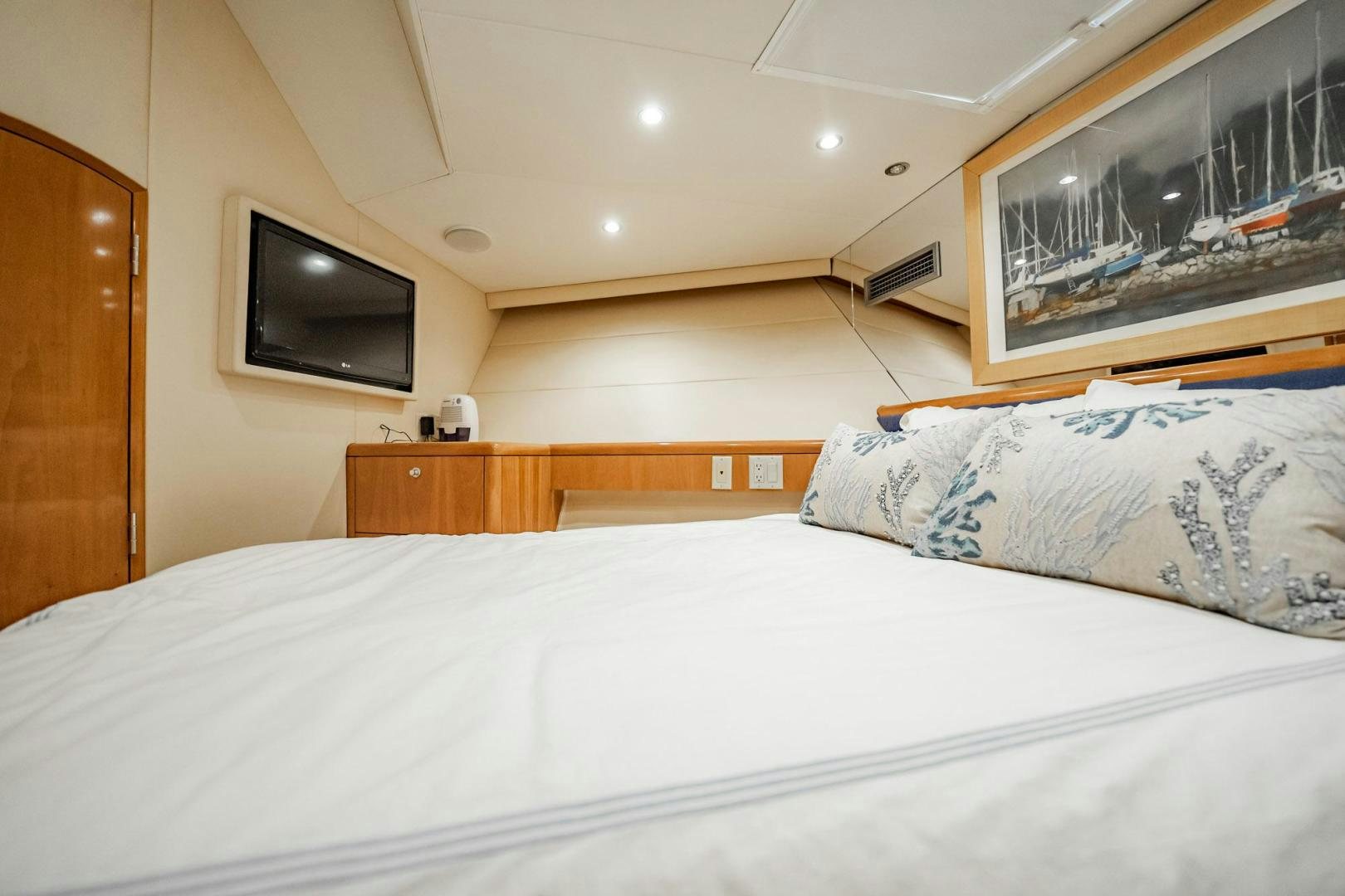 a bed with a white sheet and a television on the wall aboard CRISTINA Yacht for Sale