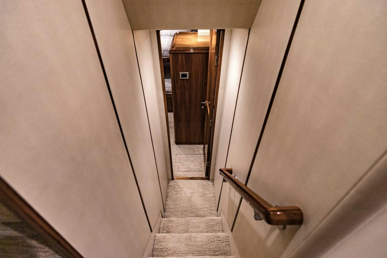 a hallway with a door and a wood railing aboard SHOE Yacht for Sale