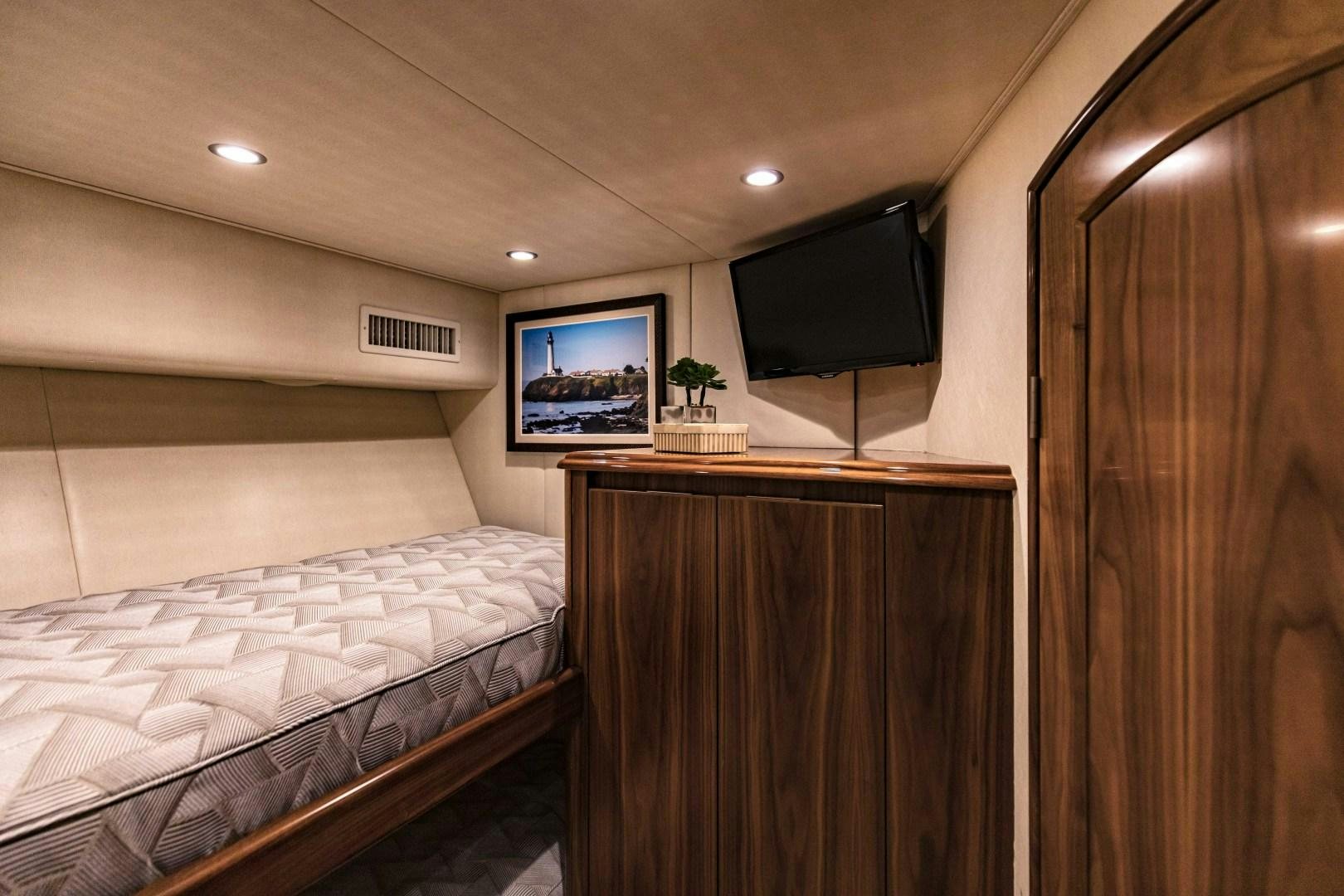 a bedroom with a tv on the wall aboard SHOE Yacht for Sale