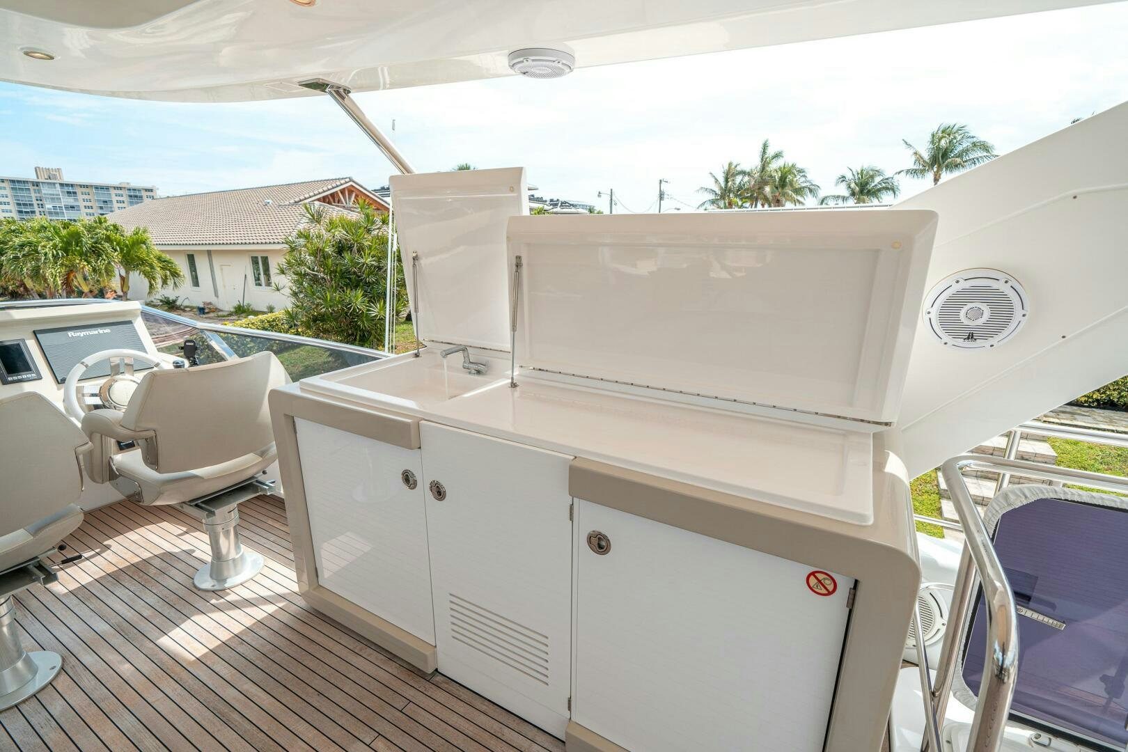 a white cabinet with a chair and a table on a deck aboard VELOCITY Yacht for Sale
