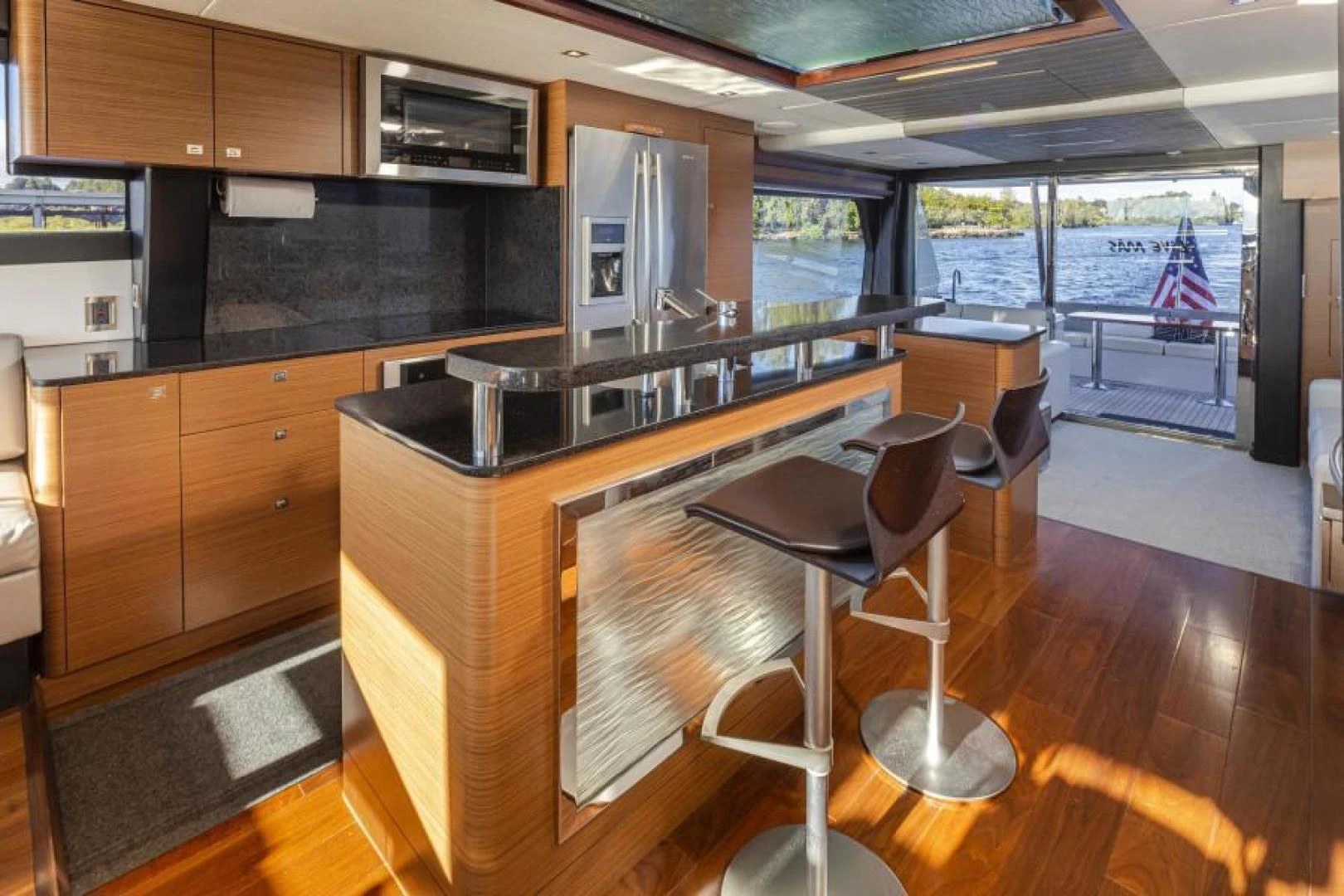 a kitchen with a bar and stools aboard LIV MAS Yacht for Sale