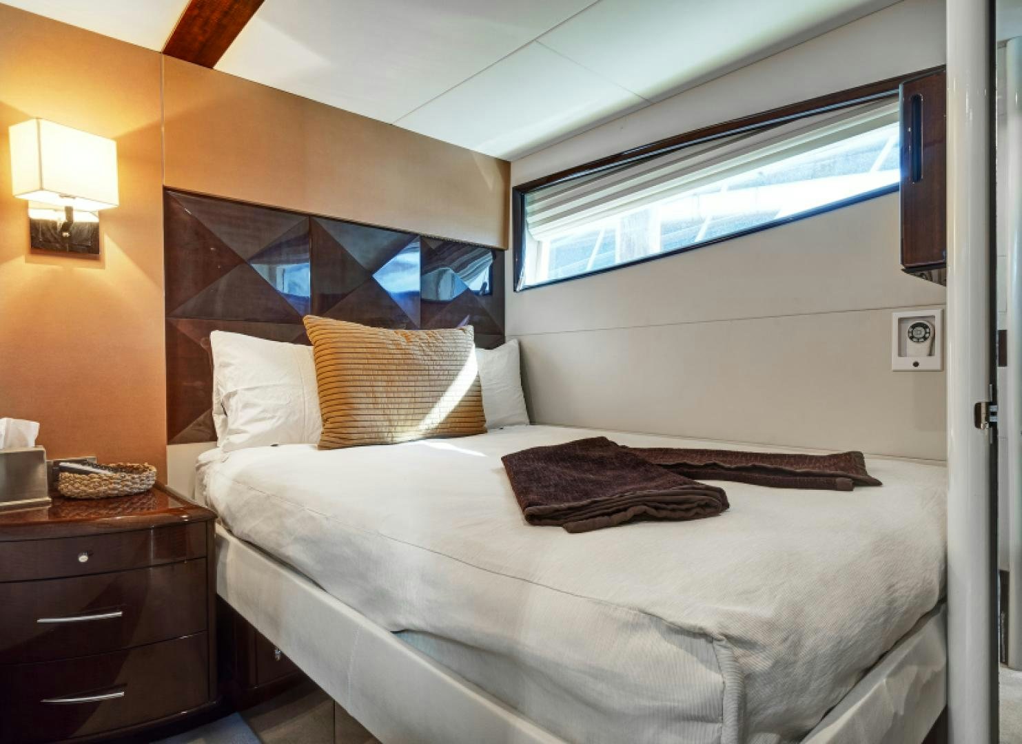 a bed with a white sheet and pillows aboard LADY H Yacht for Sale