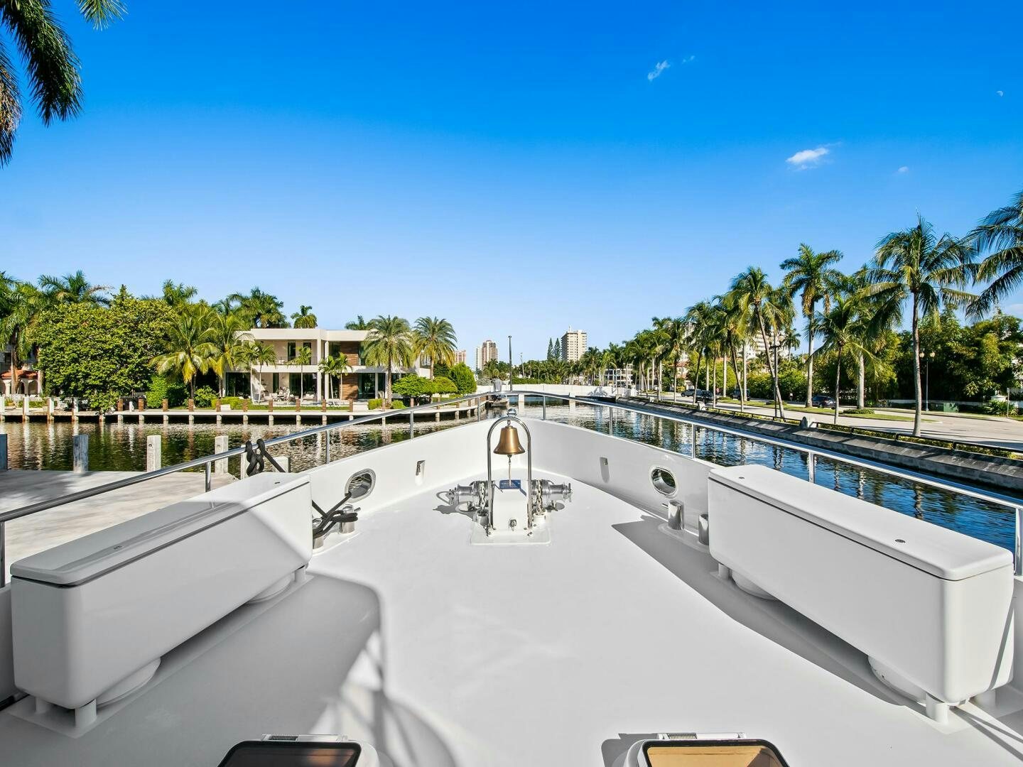 a white building with a fence around it and palm trees in the background aboard SIENNA Yacht for Sale