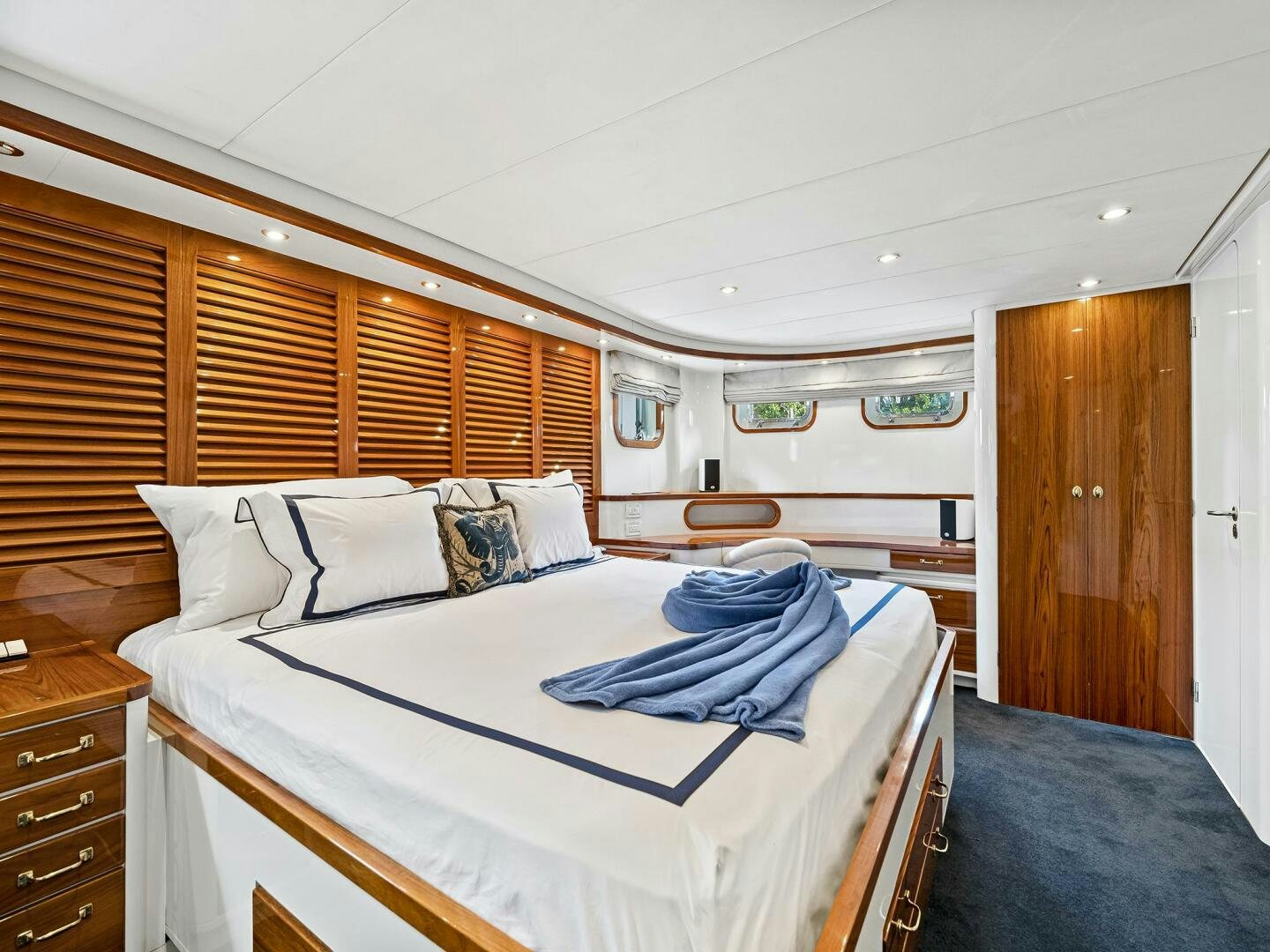 a bedroom with a bed and a wood door aboard SIENNA Yacht for Sale