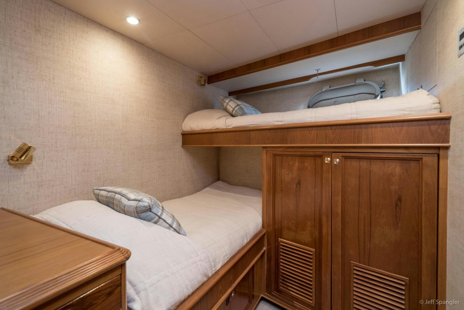 a bed with a wooden headboard aboard LIFE OF RILEY Yacht for Sale