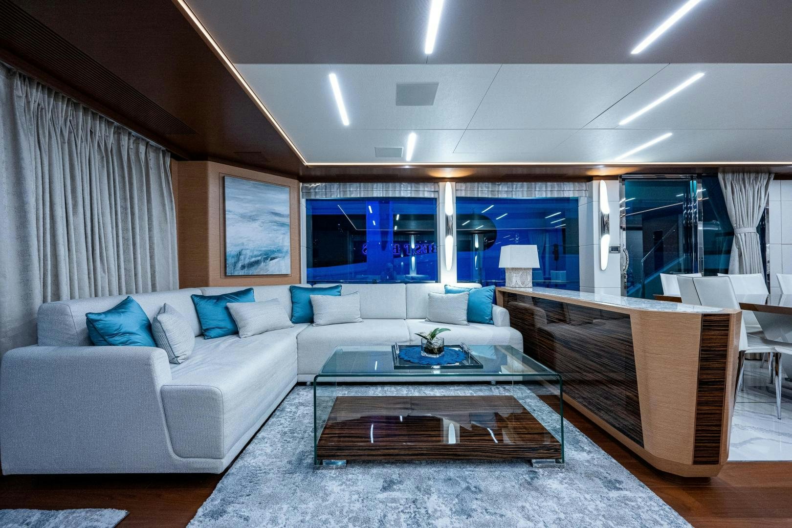 a living room with a large glass coffee table aboard SEAMENT Yacht for Sale