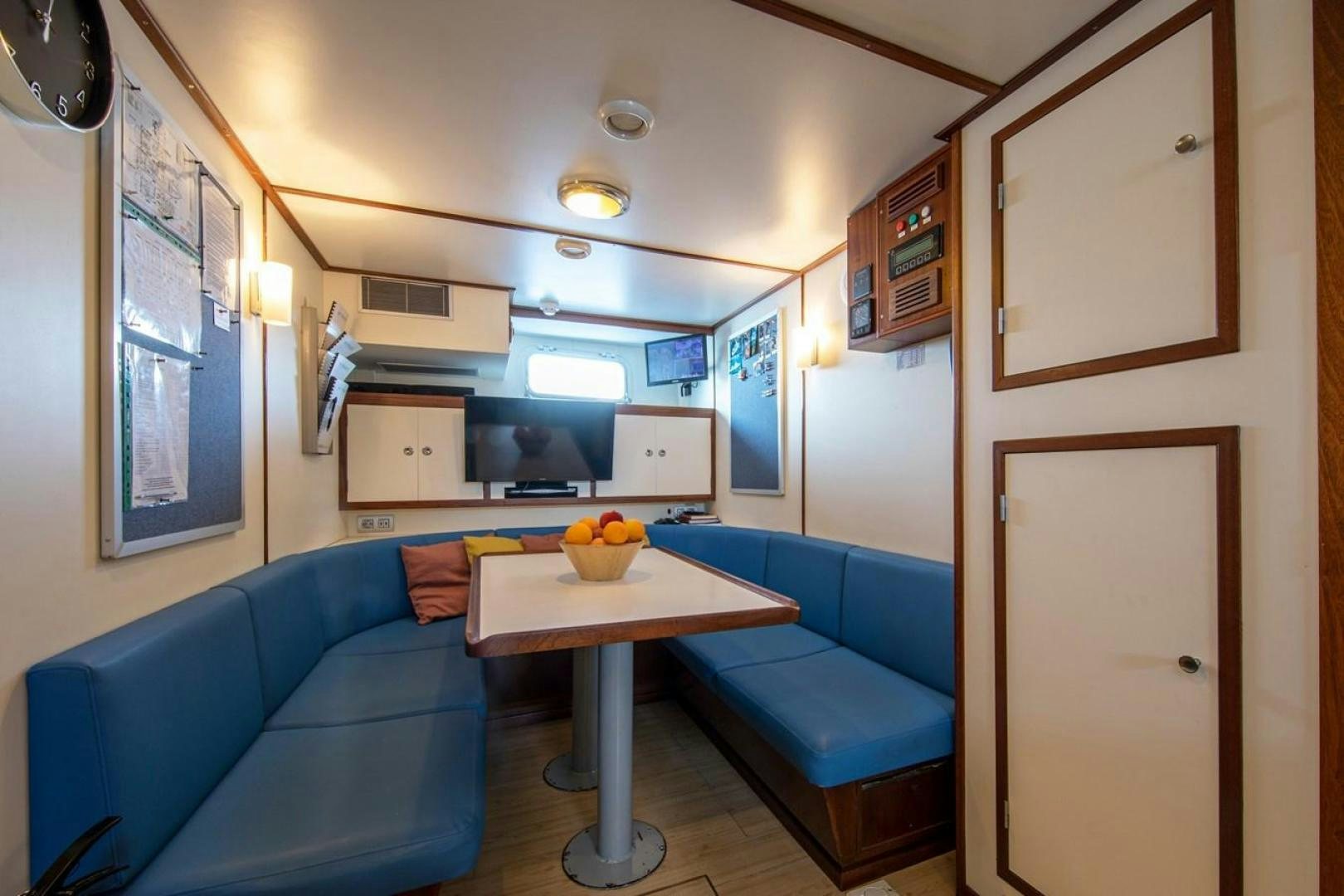 a living room with a blue couch and a table aboard MONACO Yacht for Sale