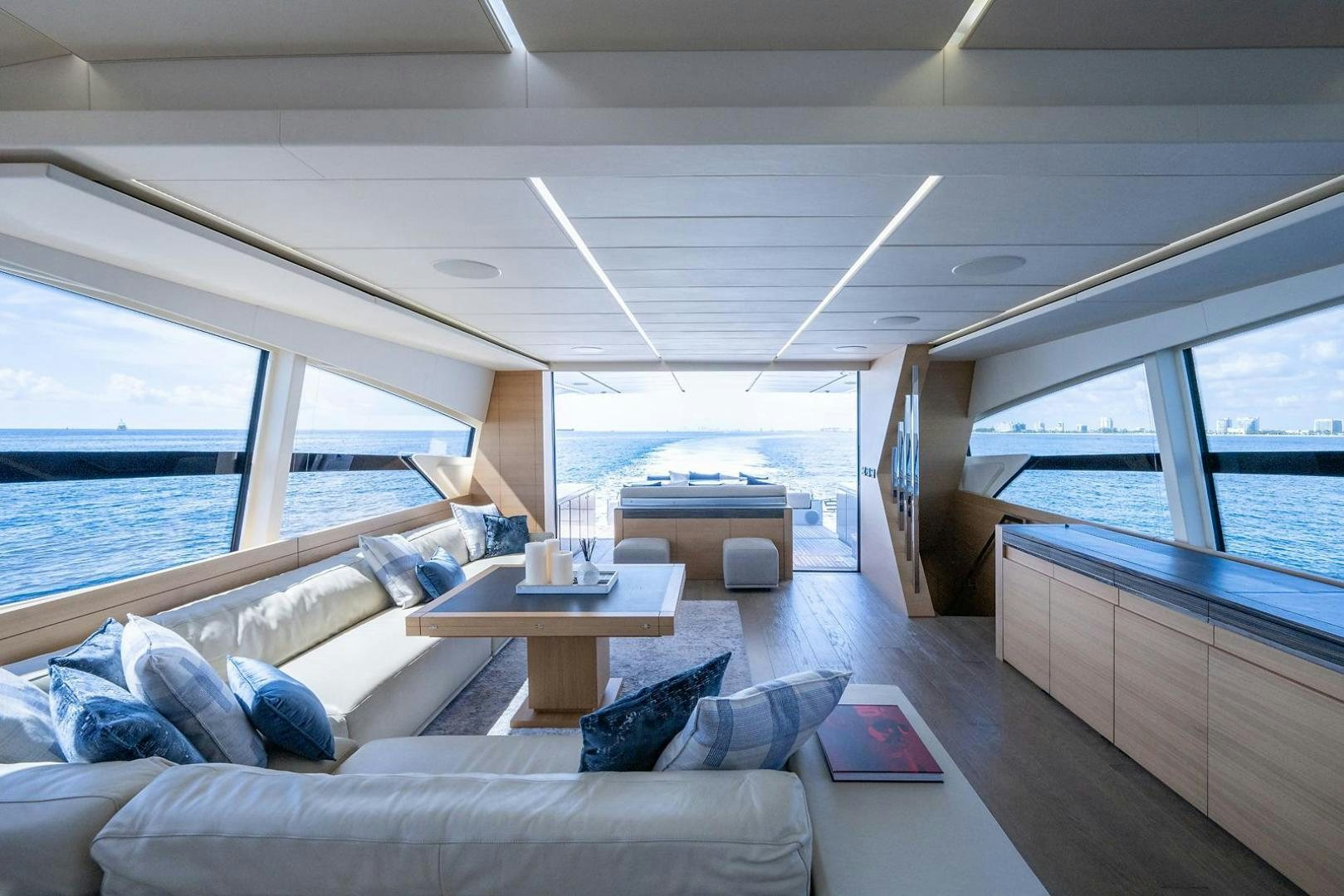 a room with a couch and a table and a view of the water aboard IMAGINE Yacht for Sale