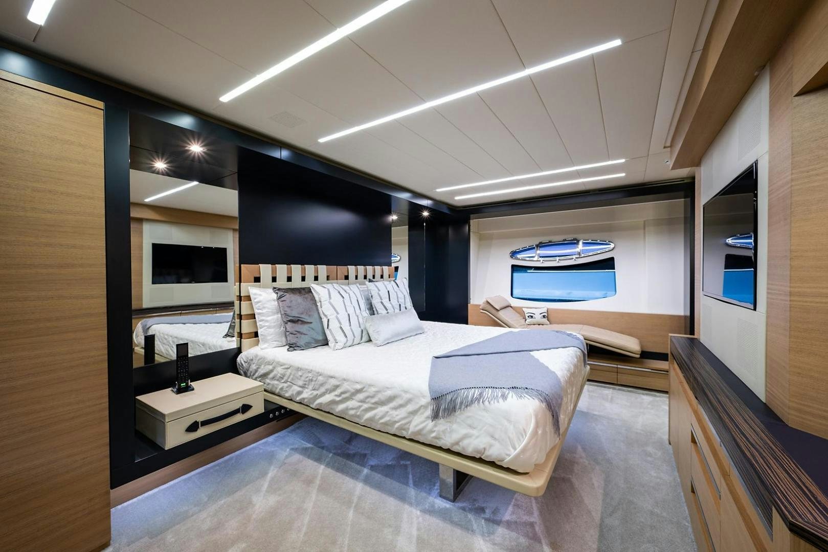 a bedroom with a bed and a large mirror aboard IMAGINE Yacht for Sale