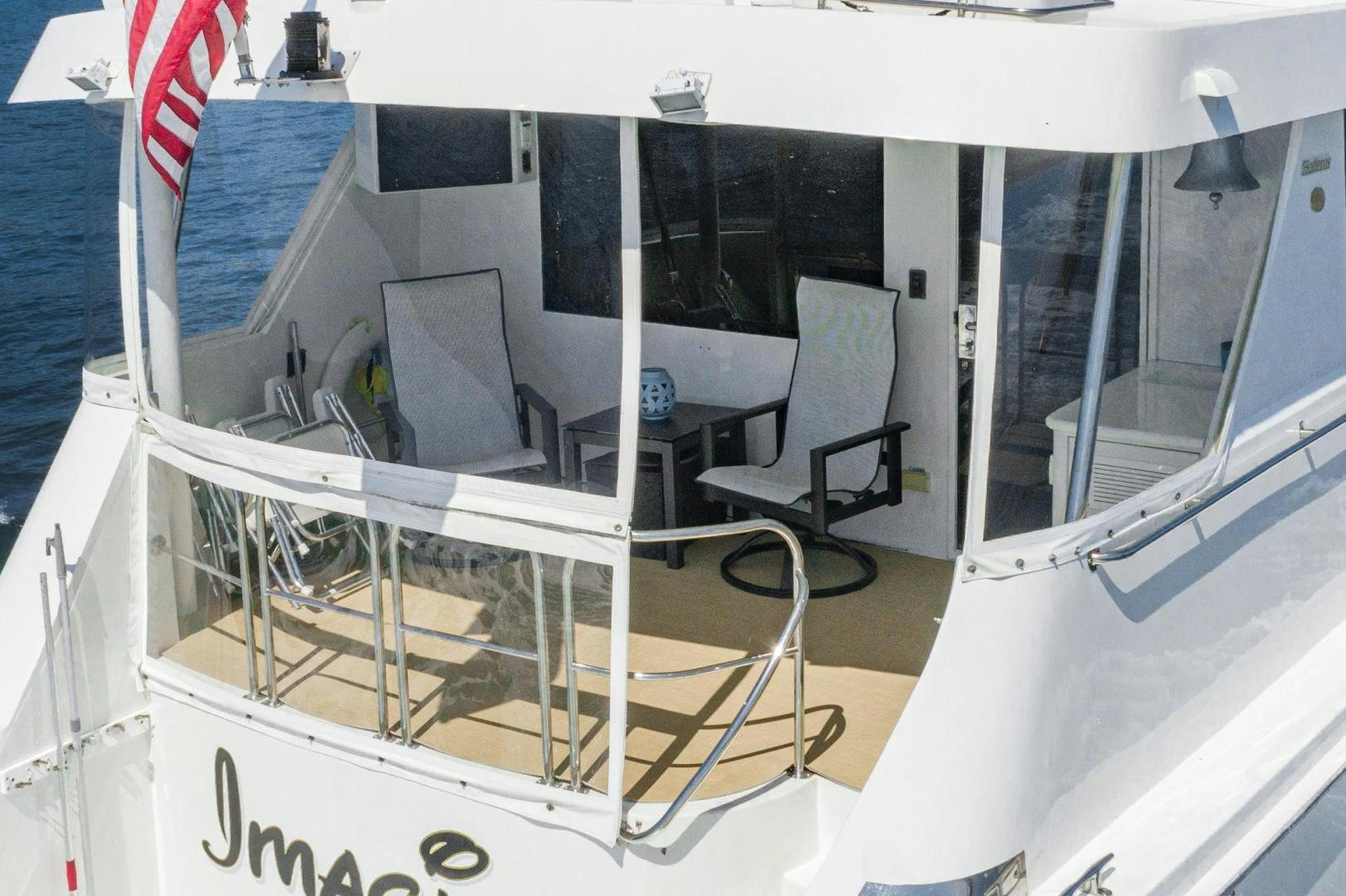 a white boat with a flag on the side aboard IMAGINE Yacht for Sale