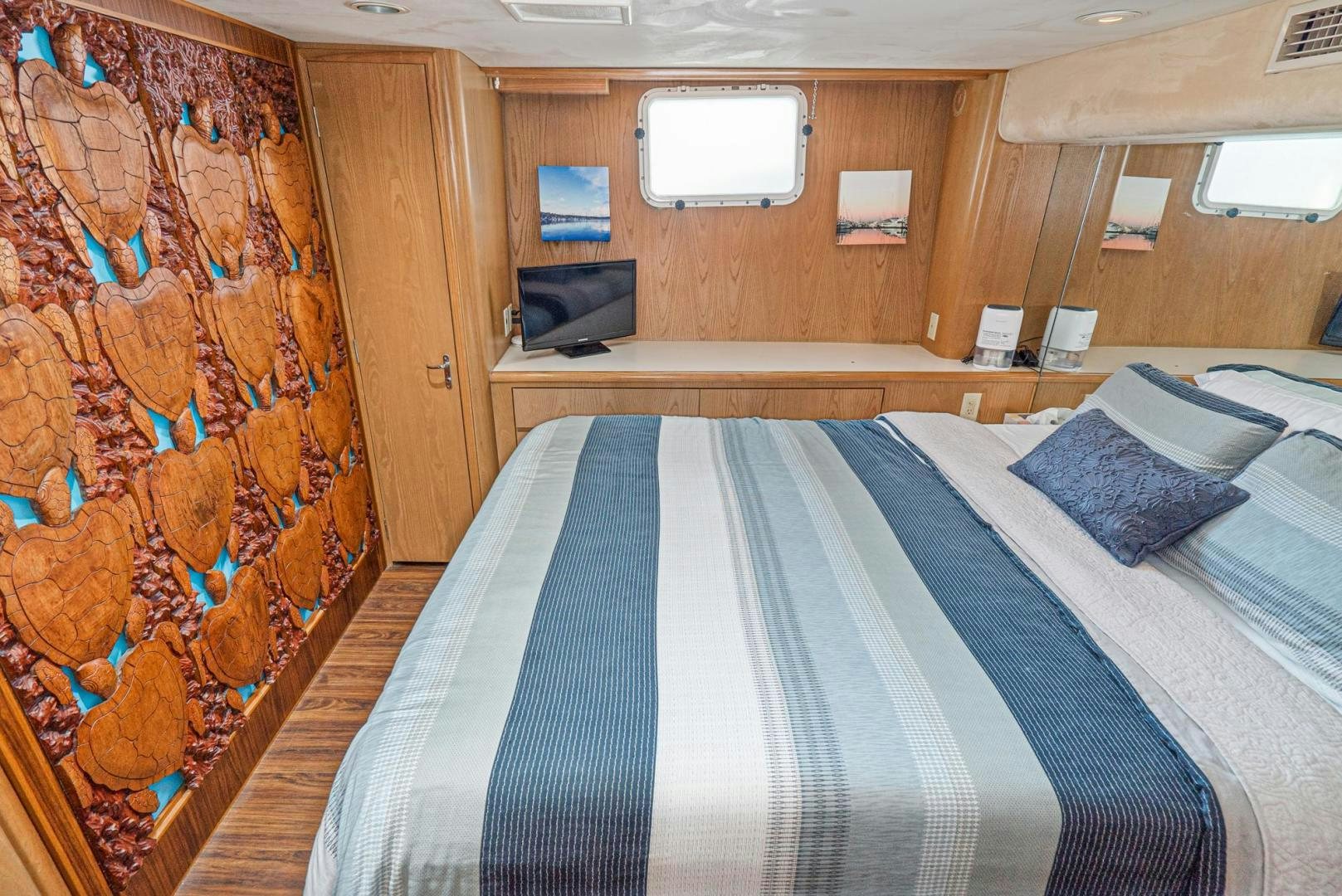 a bed with a blue and white striped blanket aboard IMAGINE Yacht for Sale