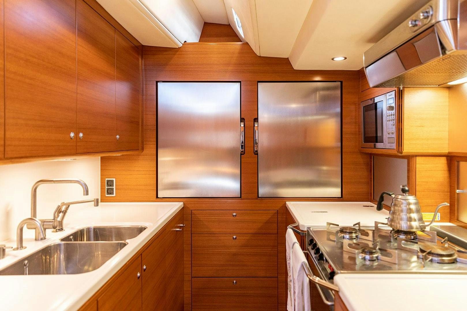 a kitchen with wooden cabinets aboard FRIDA Yacht for Sale