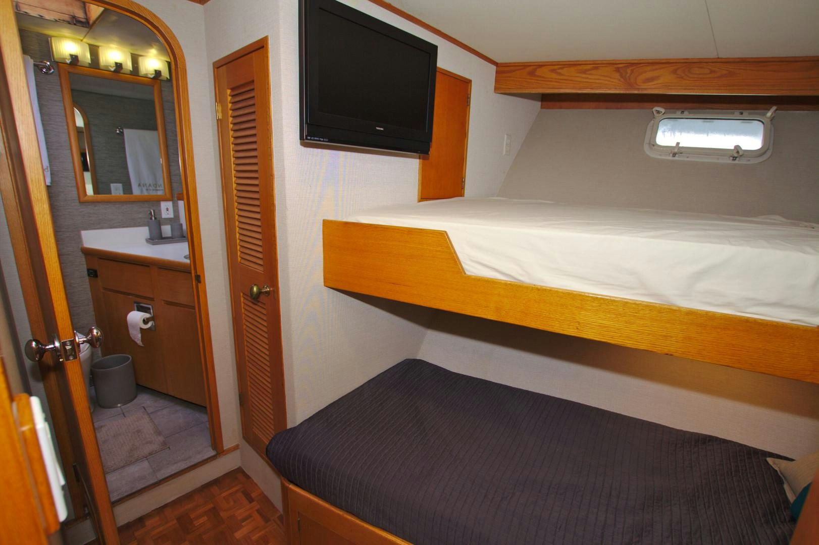 a hotel room with a bed and tv aboard PENDANA Yacht for Sale
