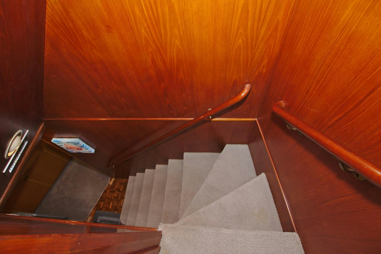 a wooden staircase with a wooden railing aboard PENDANA Yacht for Sale