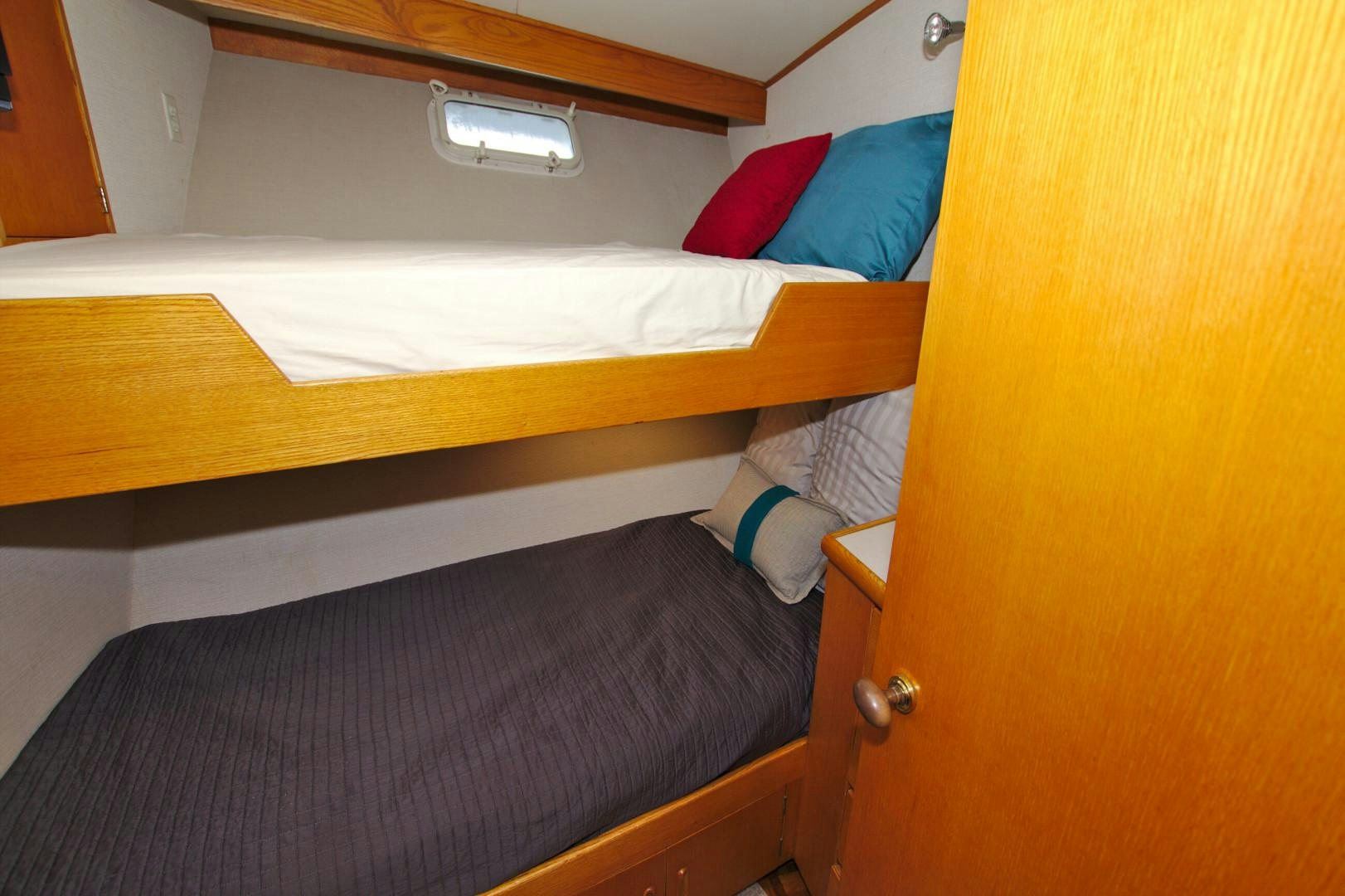 a bed with a blue pillow aboard PENDANA Yacht for Sale