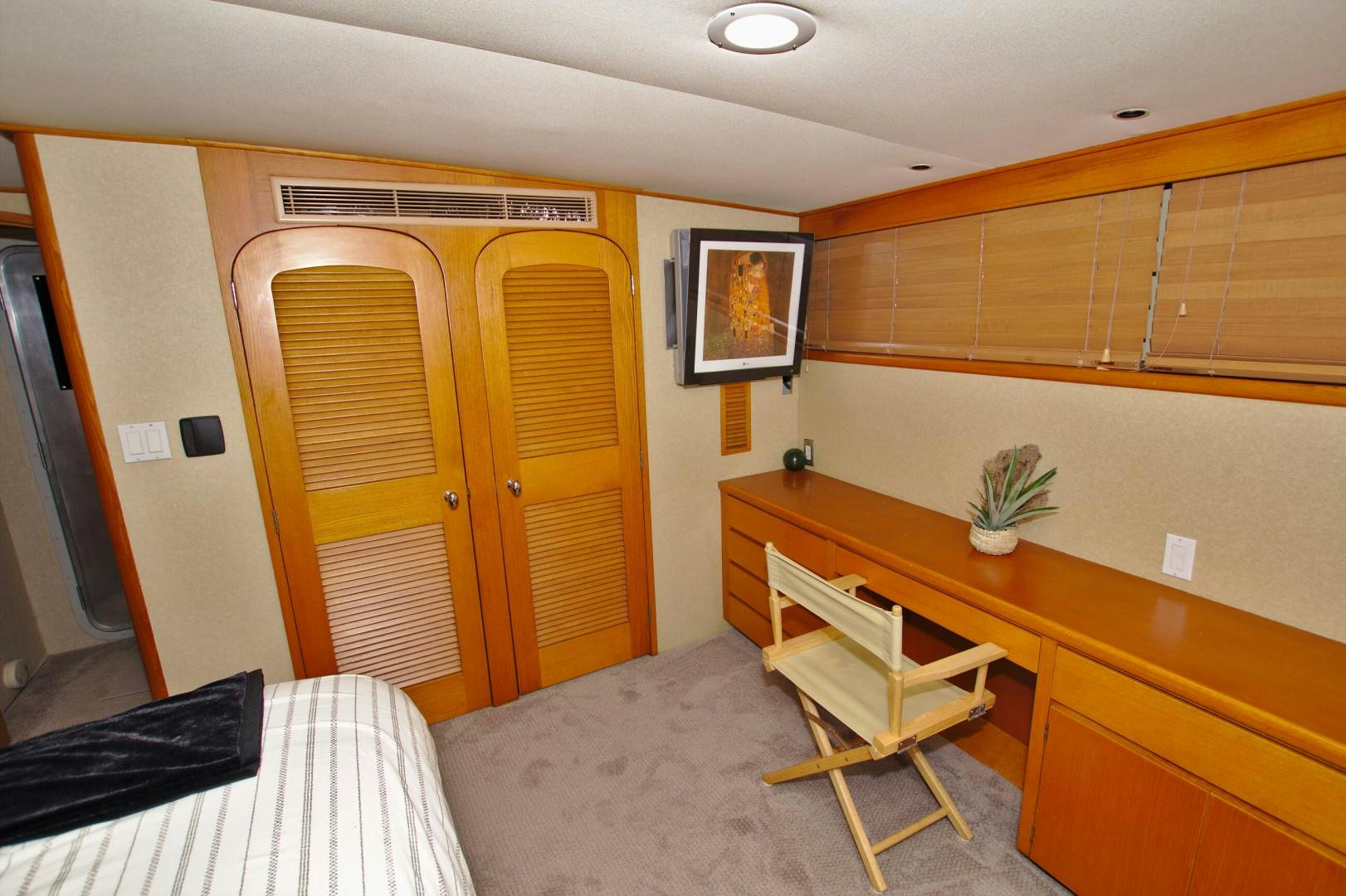 a room with a desk and a bed aboard PENDANA Yacht for Sale