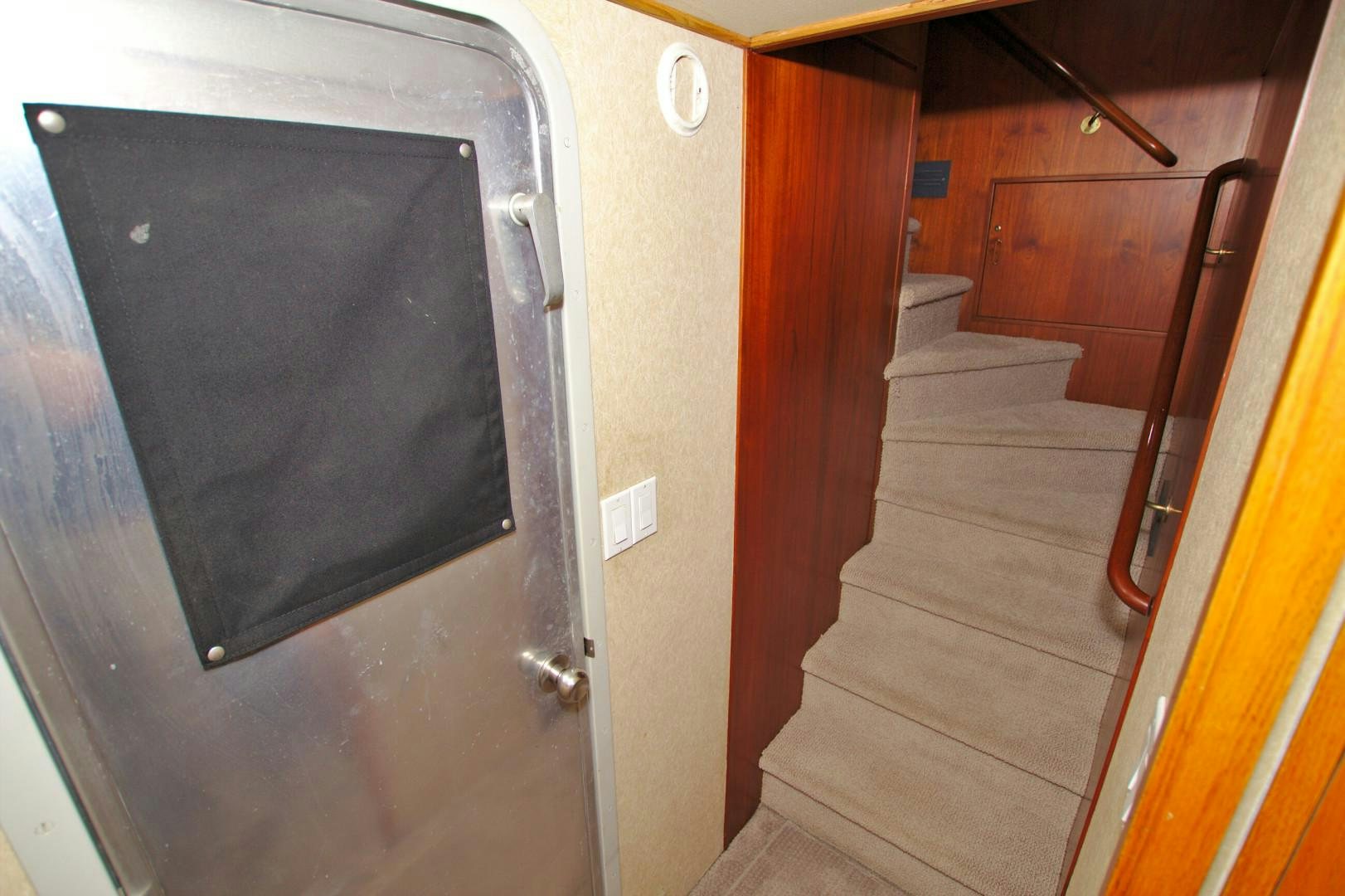 a black rectangular object on a white surface next to a wooden door aboard PENDANA Yacht for Sale