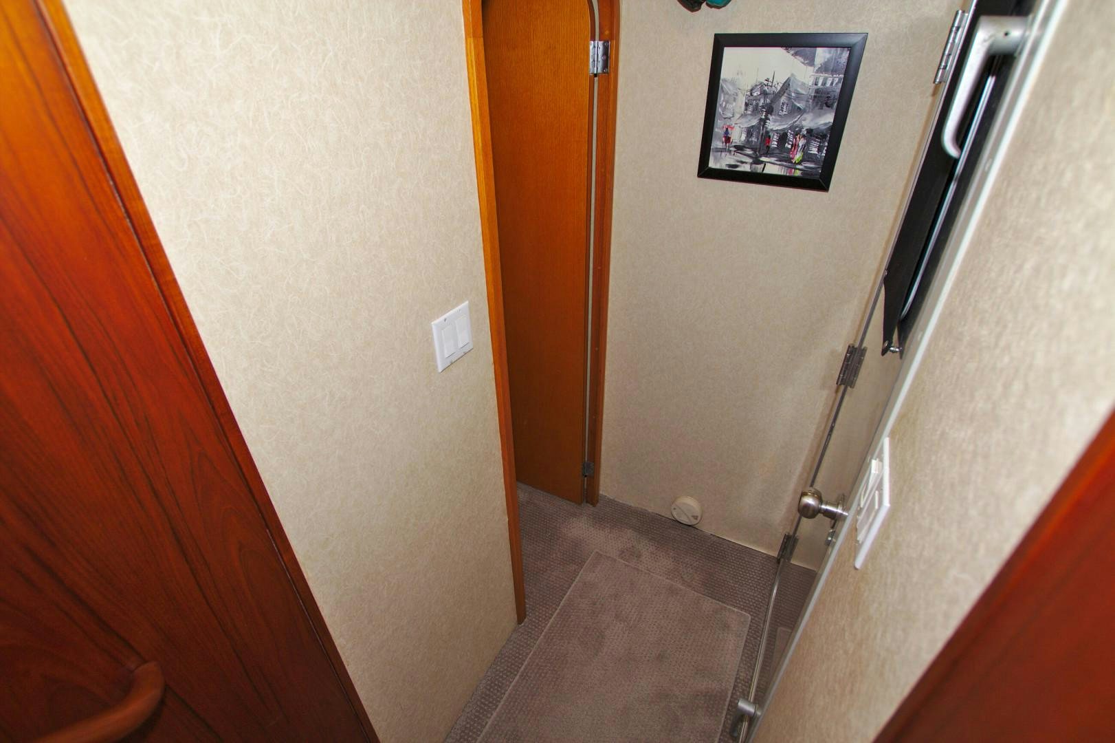 a hallway with a door and a painting on the wall aboard PENDANA Yacht for Sale