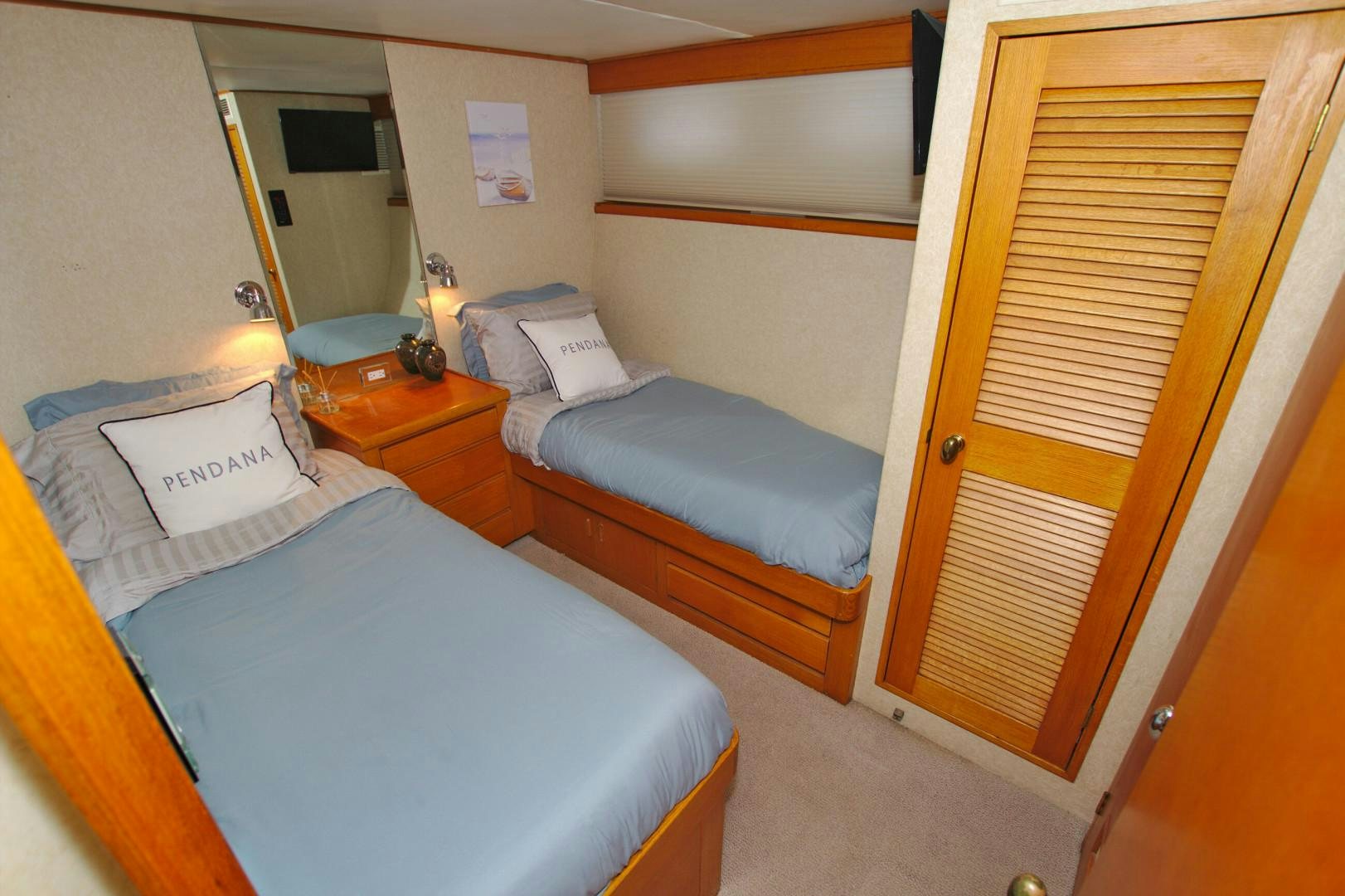 a room with beds and a wood door aboard PENDANA Yacht for Sale