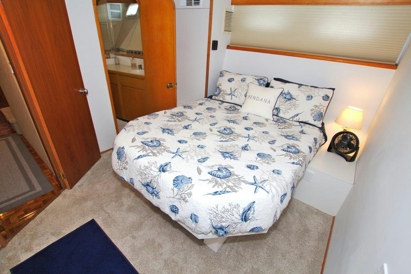 a bed with blue and white sheets aboard PENDANA Yacht for Sale