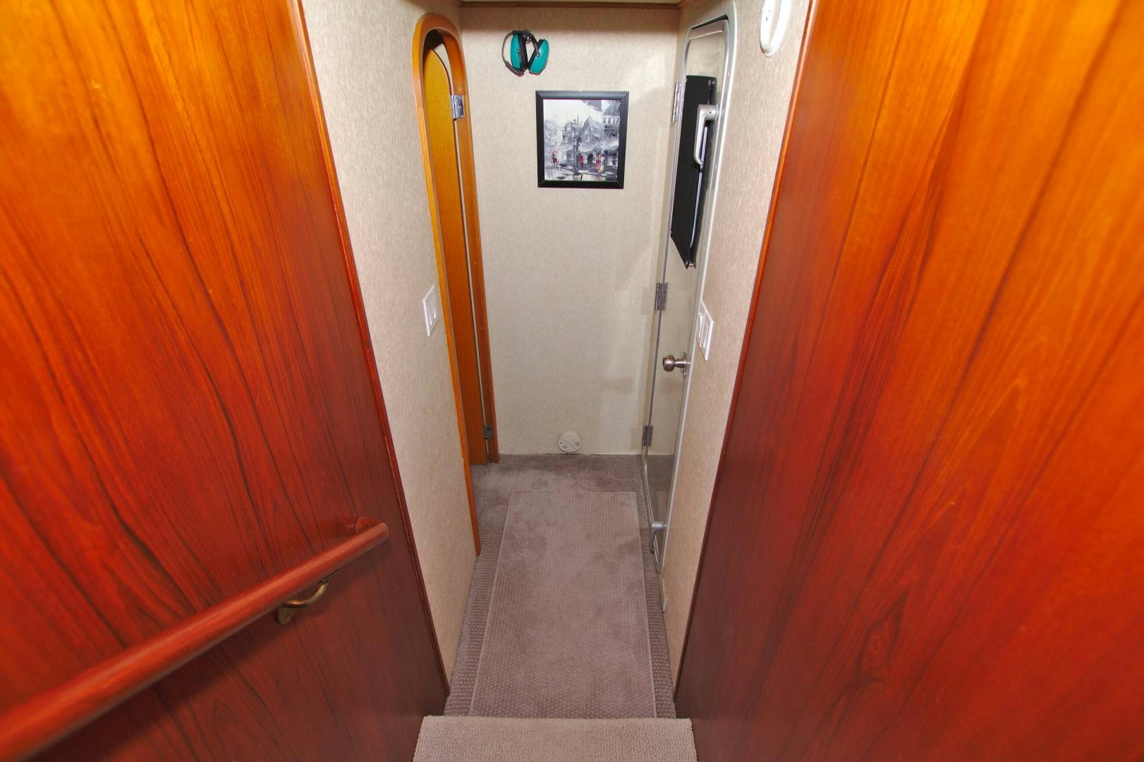 a hallway with a door and a painting on the wall aboard PENDANA Yacht for Sale