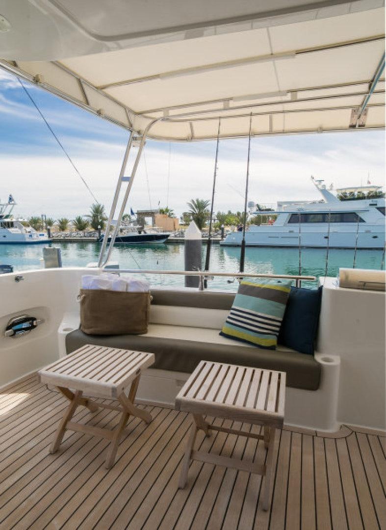 a deck with chairs and a table on it aboard CONDORS NEST Yacht for Sale