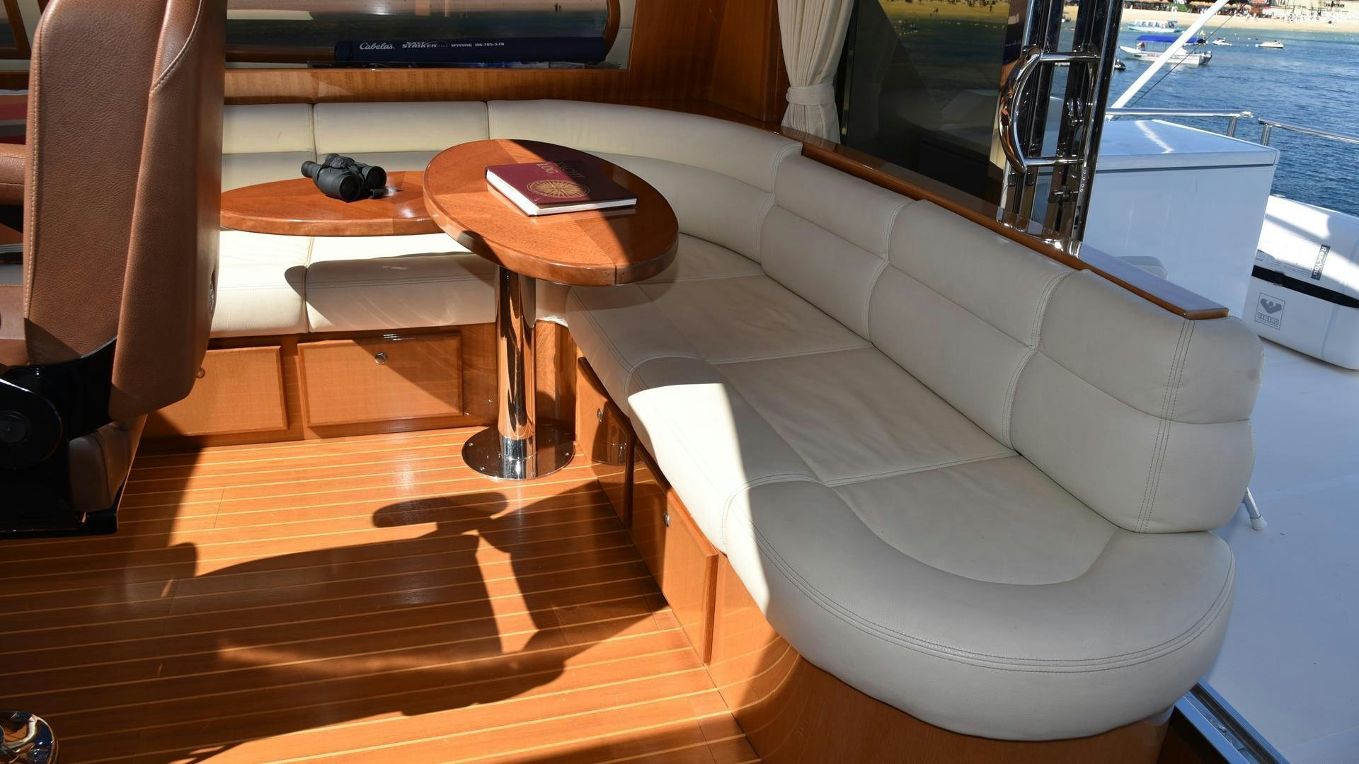 a white lounge chair with a wood table and a black coffee table aboard CONDORS NEST Yacht for Sale