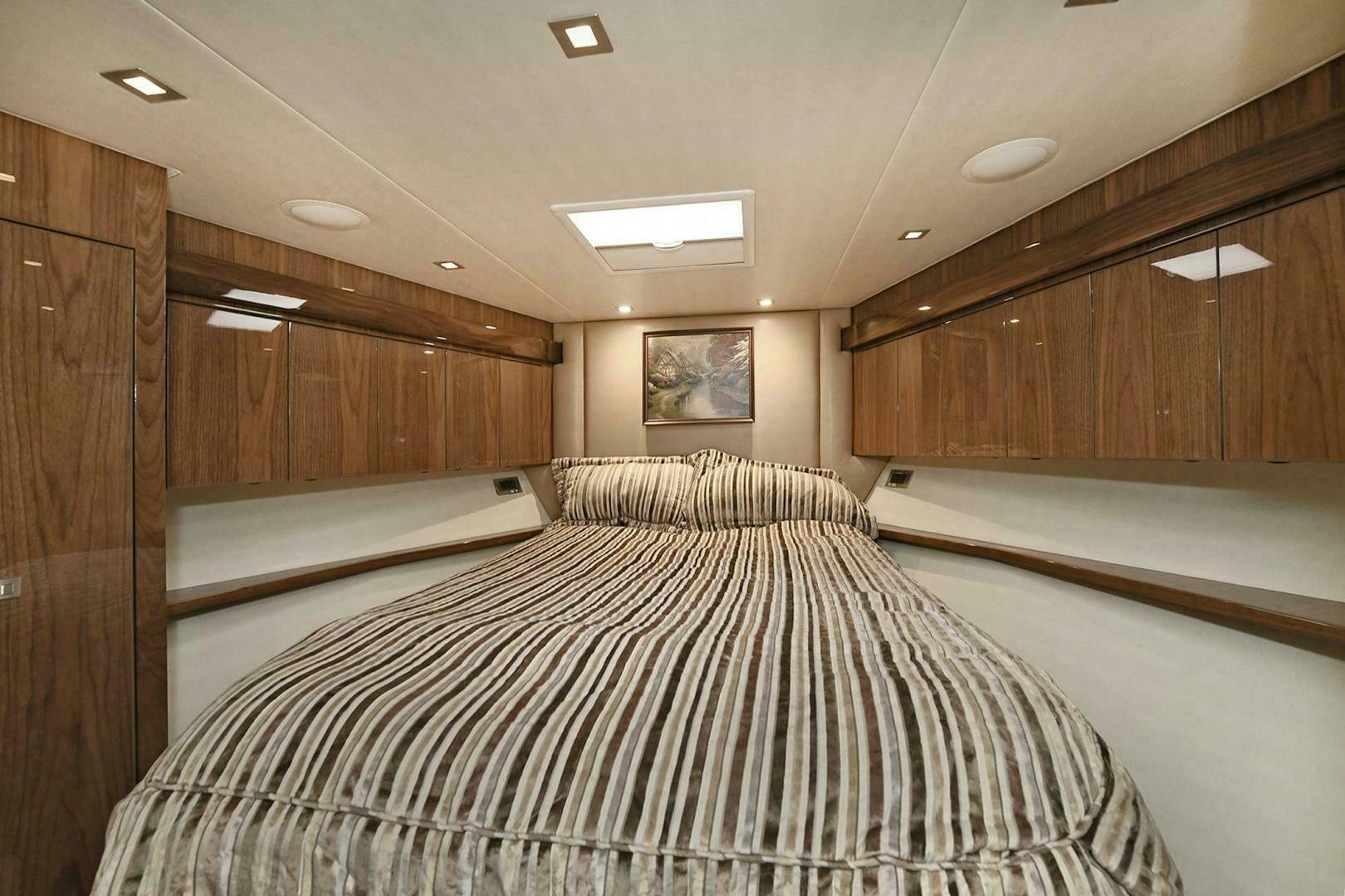 a room with a bed and cabinets aboard ON THE EDGE Yacht for Sale