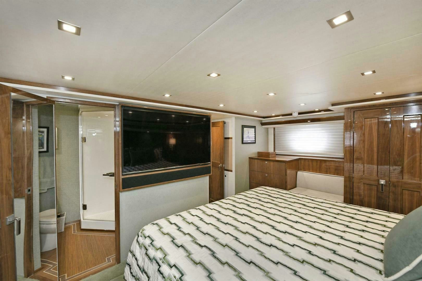 a bedroom with a bed and a television aboard ON THE EDGE Yacht for Sale