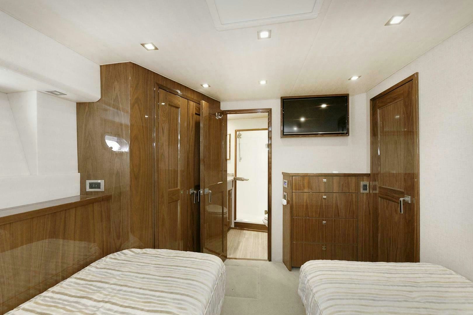 a bedroom with a bed and a wood door aboard ON THE EDGE Yacht for Sale