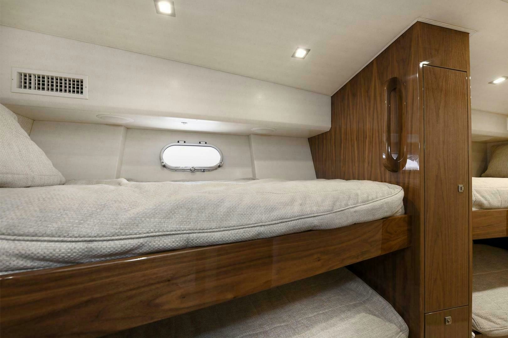 a bed with a wooden headboard aboard ON THE EDGE Yacht for Sale