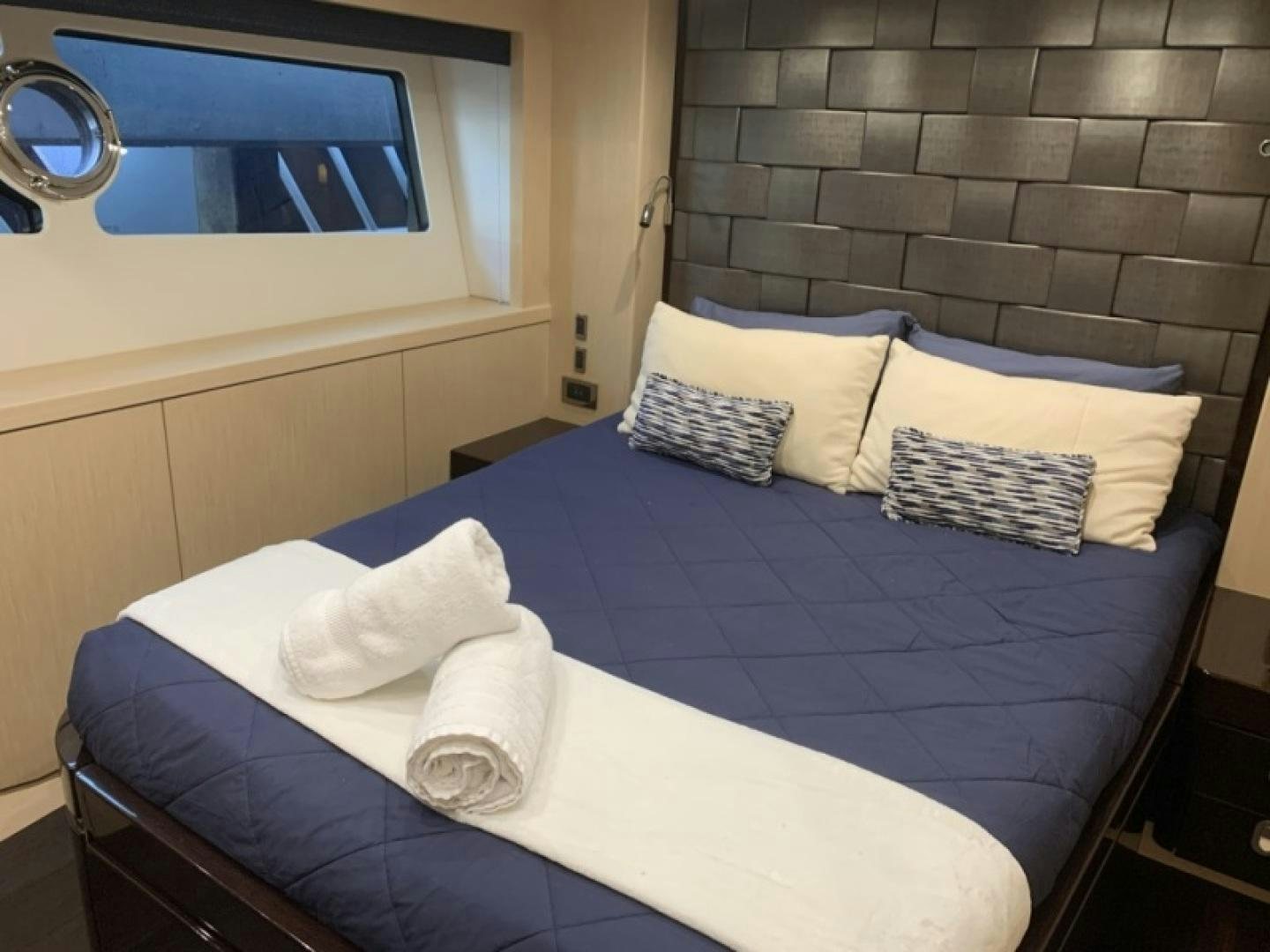 a bed with blue and white sheets aboard NBLUE Yacht for Sale