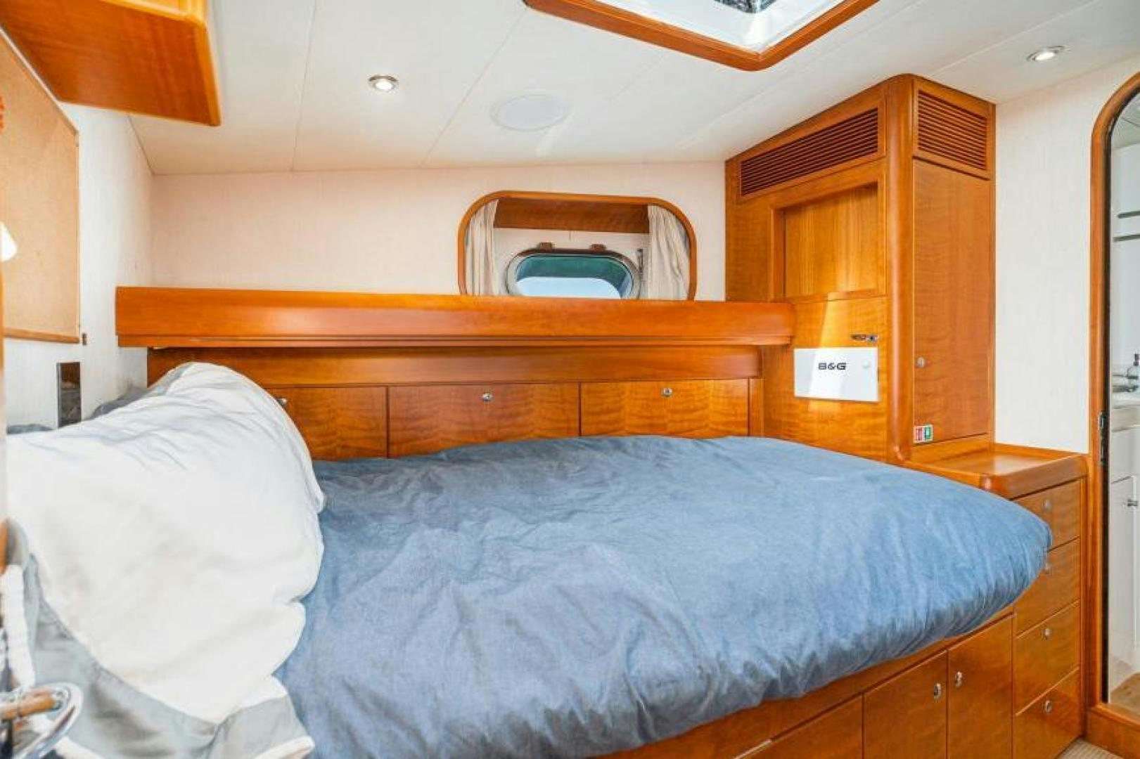 a bed with a blue comforter aboard PALIADOR Yacht for Sale