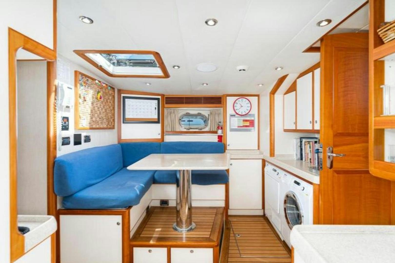 a kitchen with a table and chairs aboard PALIADOR Yacht for Sale