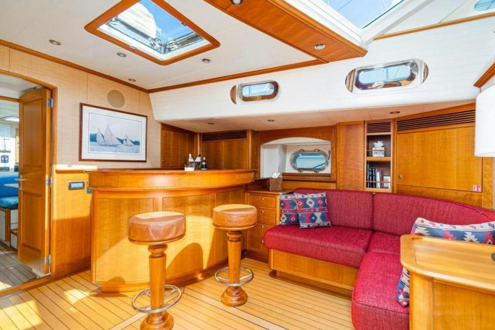 a living room with a red couch and a wood table aboard PALIADOR Yacht for Sale