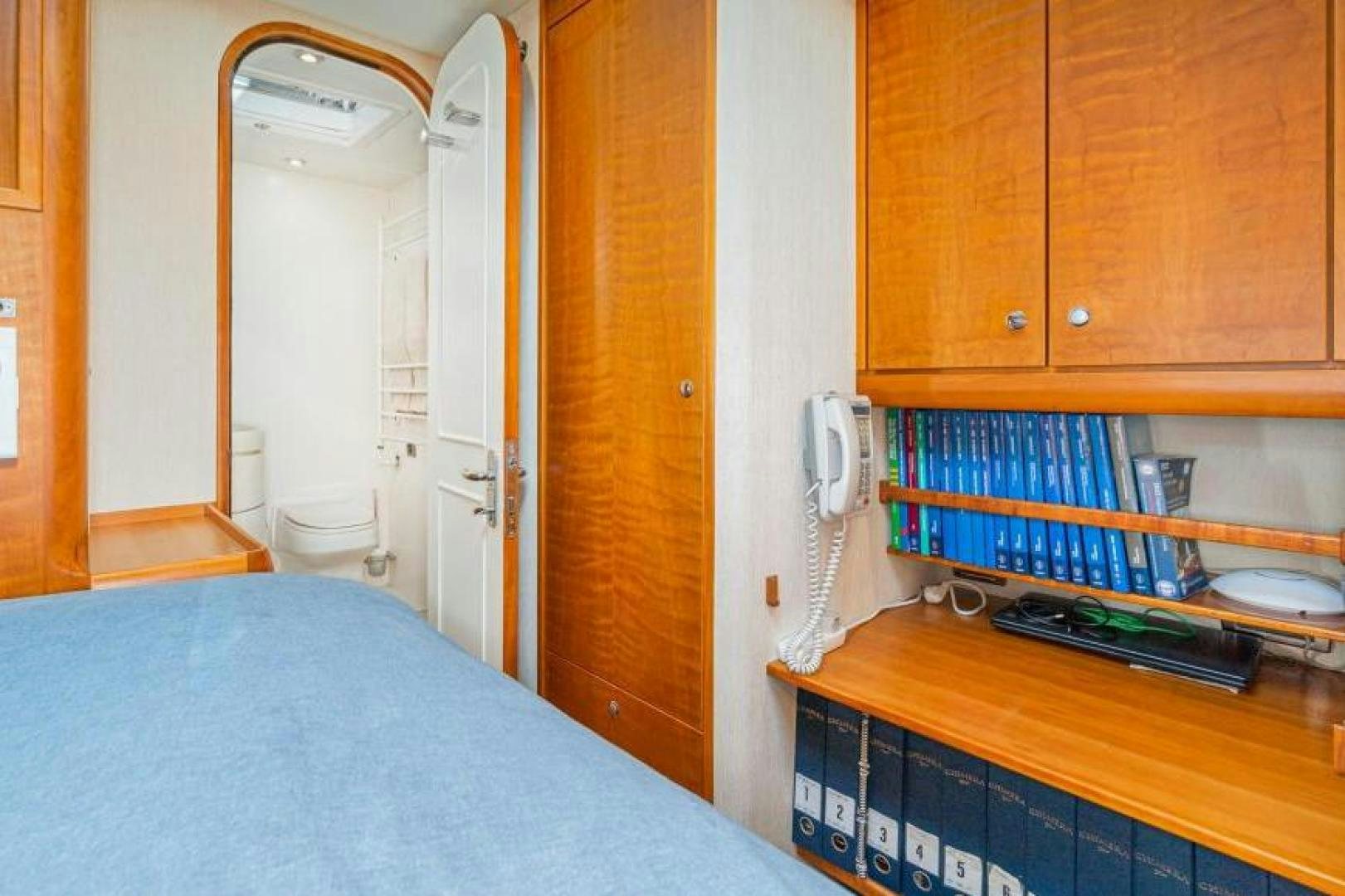 a bedroom with a book shelf and a bed aboard PALIADOR Yacht for Sale