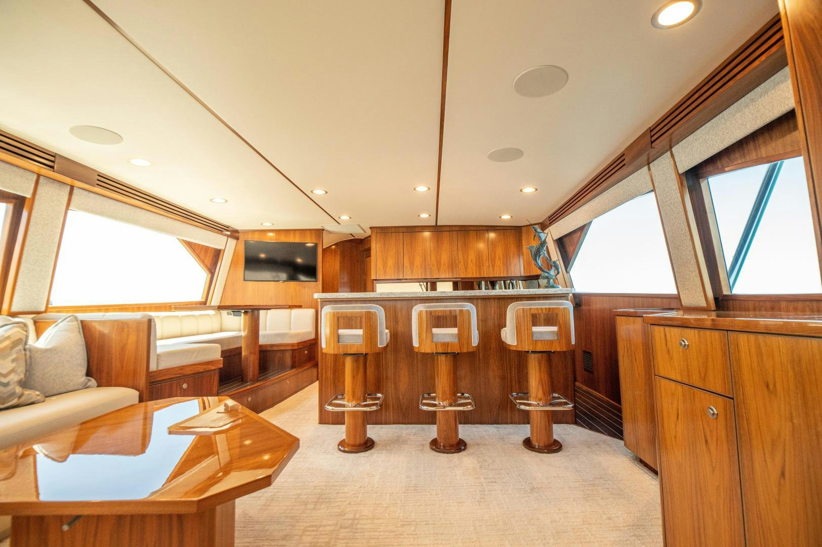 a room with a wood table and a couch and a wood cabinet aboard RAGIN CAJUN Yacht for Sale
